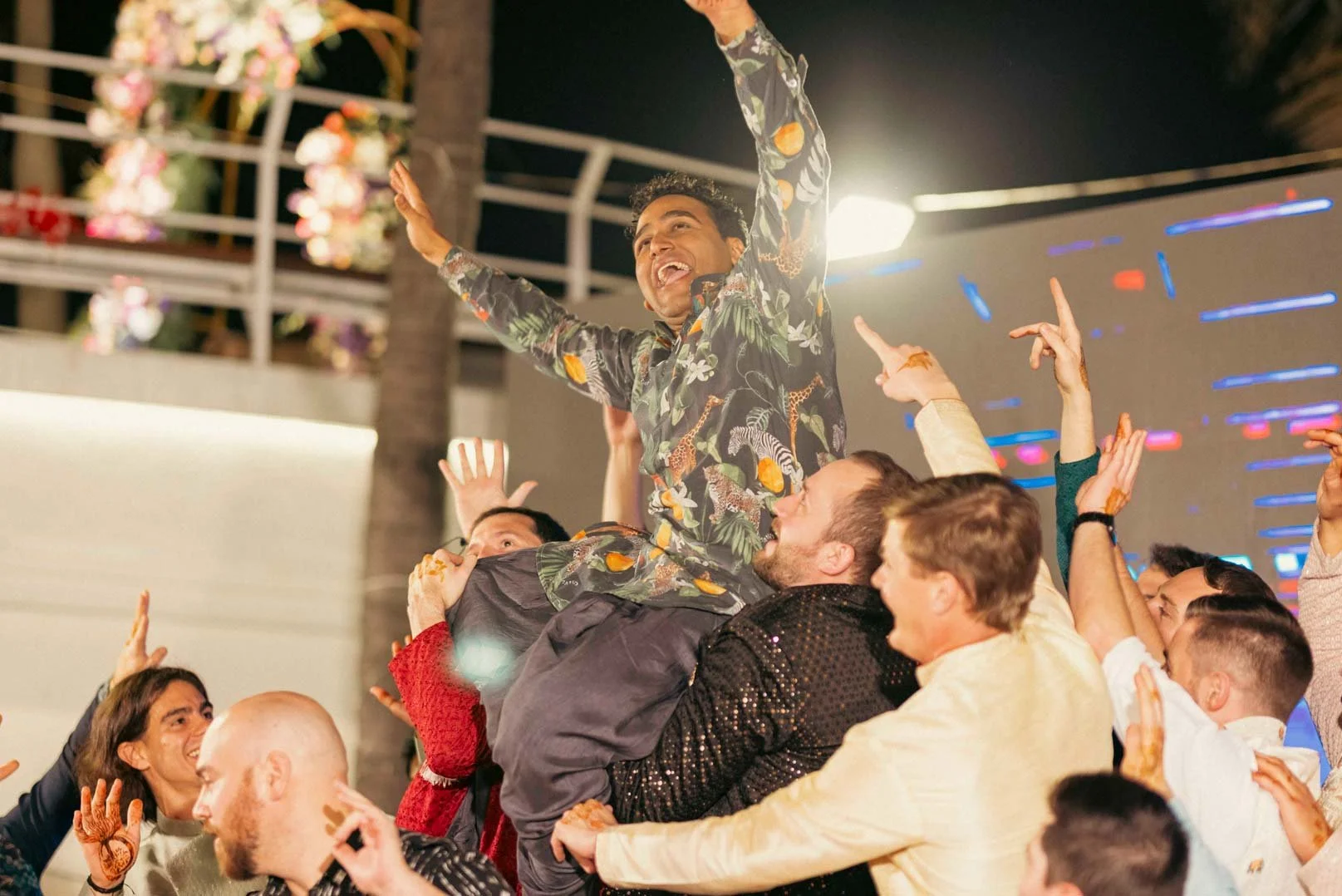 Groom being lifted by his friends during sangeeth performance