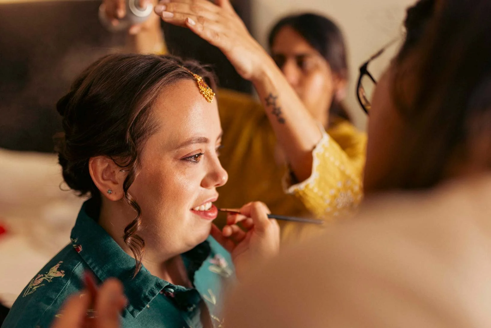 American bride gets ready  as the make up artist works on her for her  traditional South Indian wedding ceremony