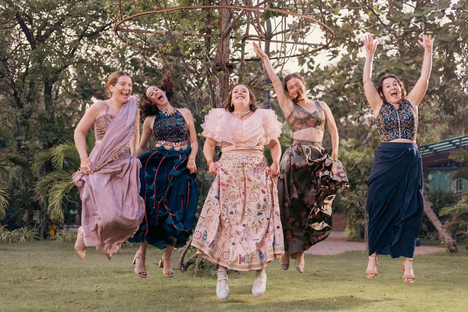 Bride and her bridesmaid friends jump up in the air for a lovely group wedding picture