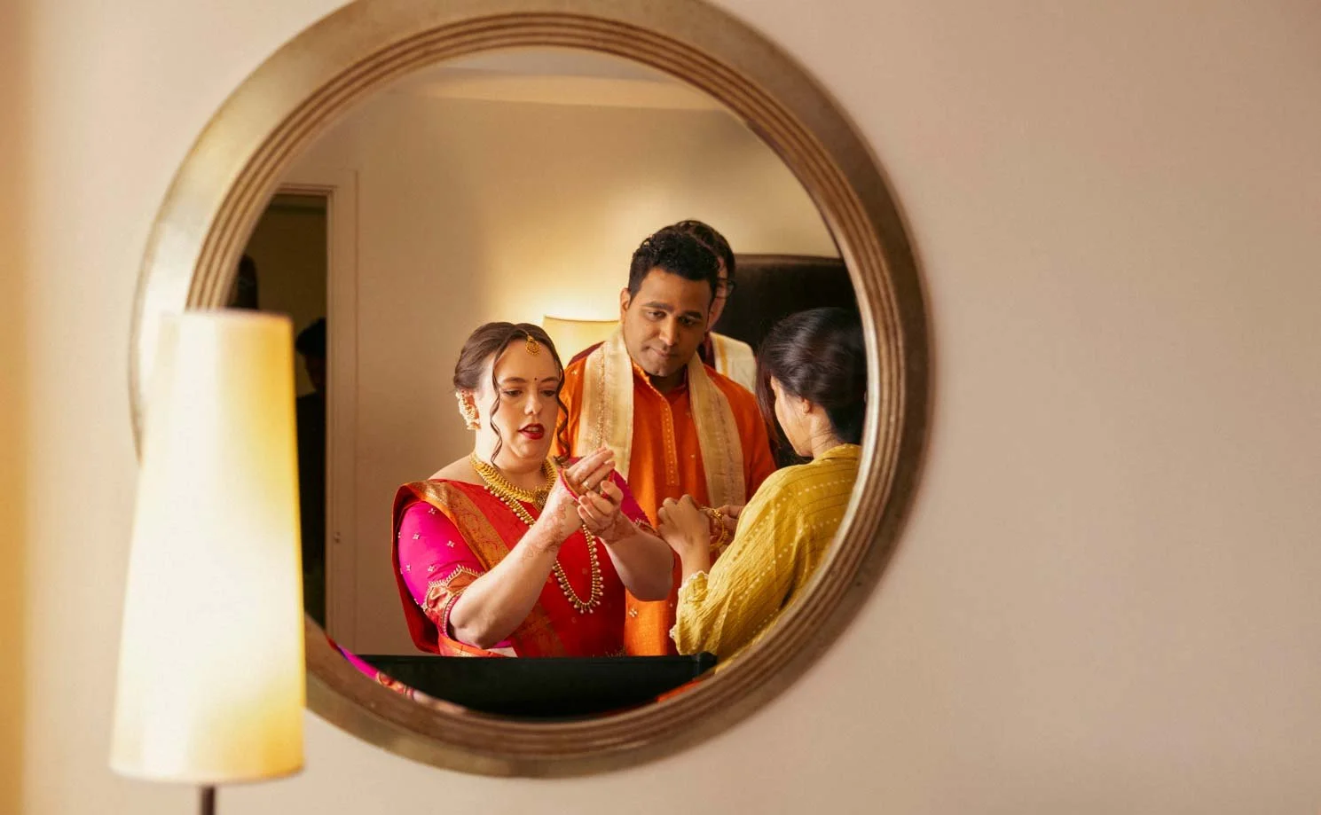 American bride gets ready  as the make up artist works on her and the groom looks on for their  traditional South Indian wedding ceremony 