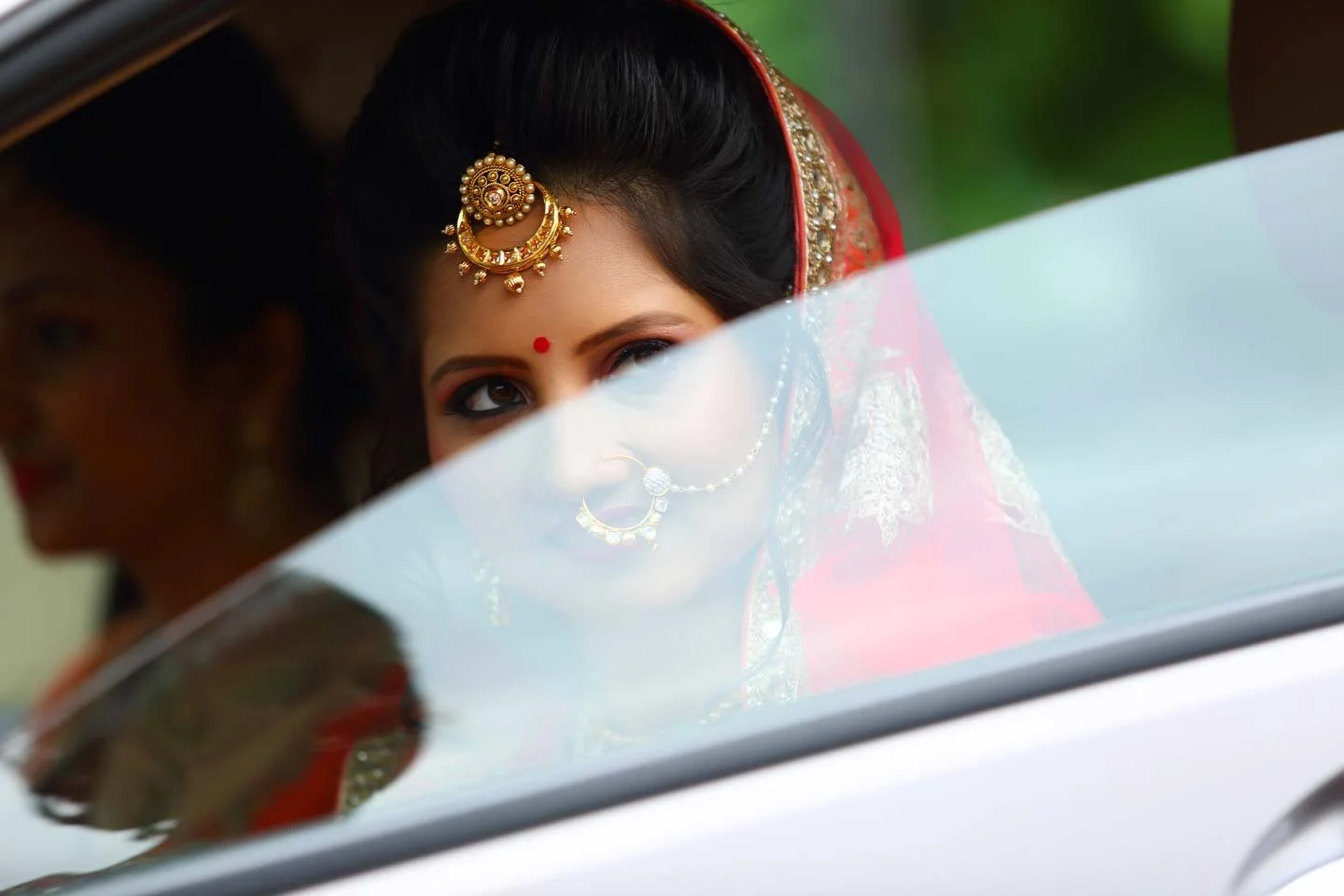 Indian bride looks on from her car
