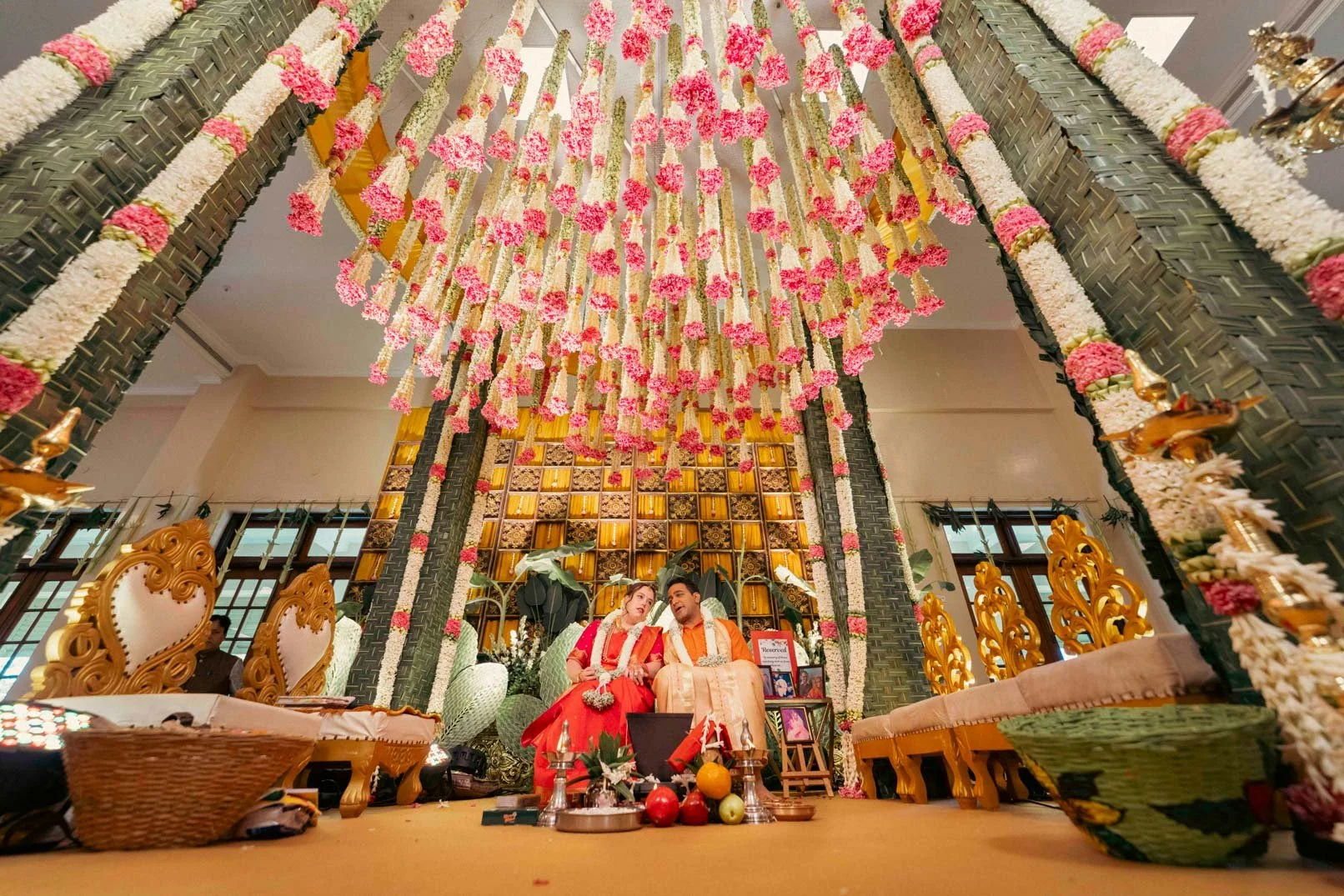 South Indian Wedding Couple Photo with the  traditional decoration and mandap with palm leaves in the background