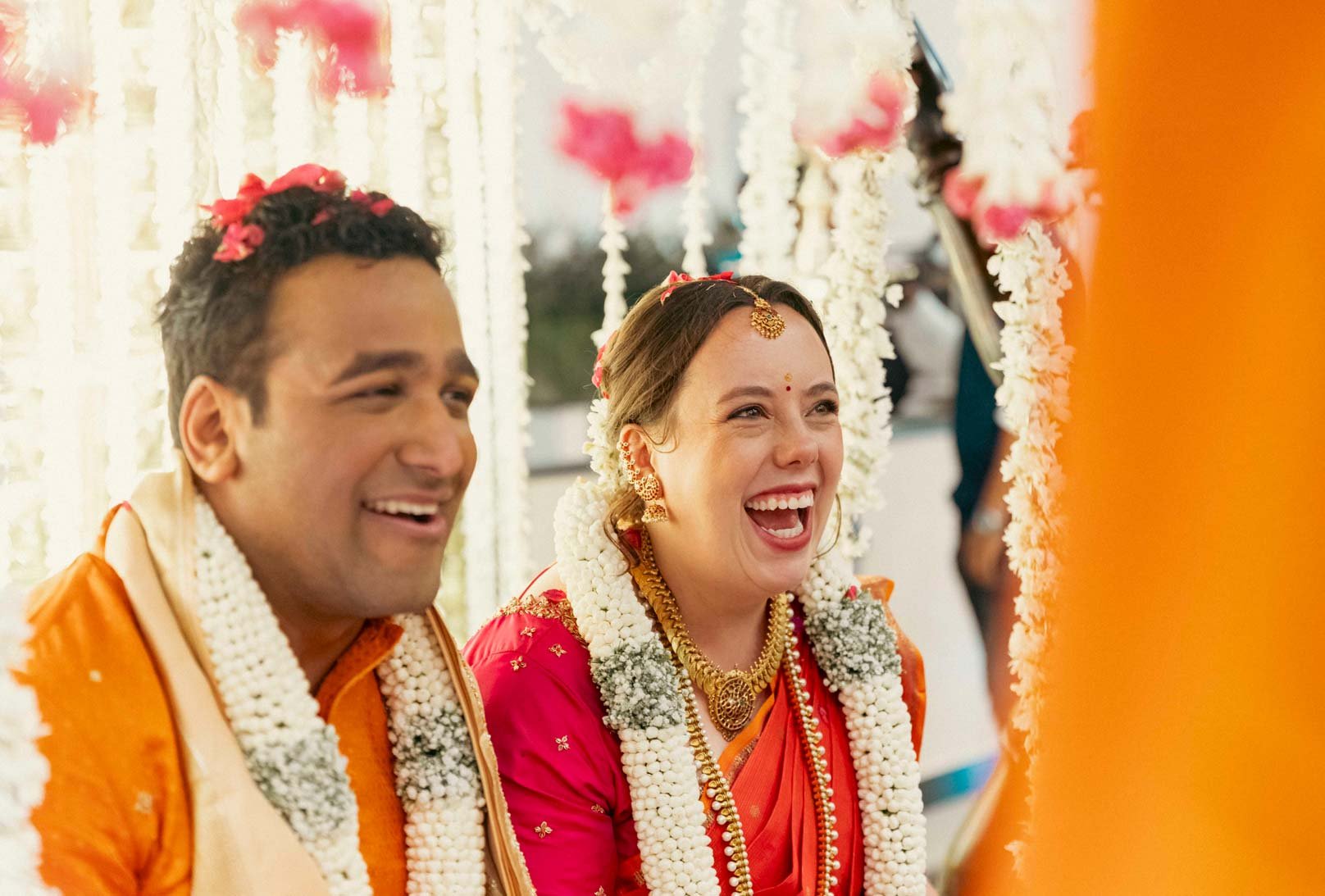 Candid moment as guest greets and blesses groom and bride in traditional oonjal ceremony in South Indian Wedding