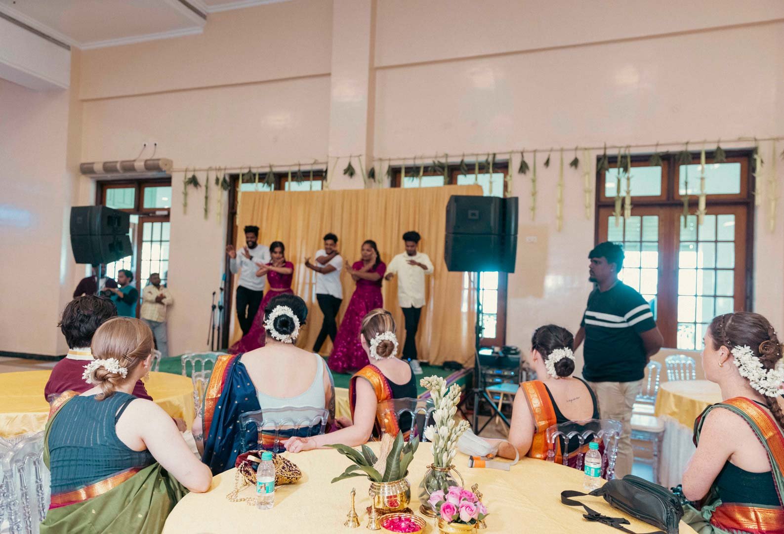 Back shot of American bridesmaids in Indian attire with jasmine flowers on the hairdo in South INdian Wedding ceremony