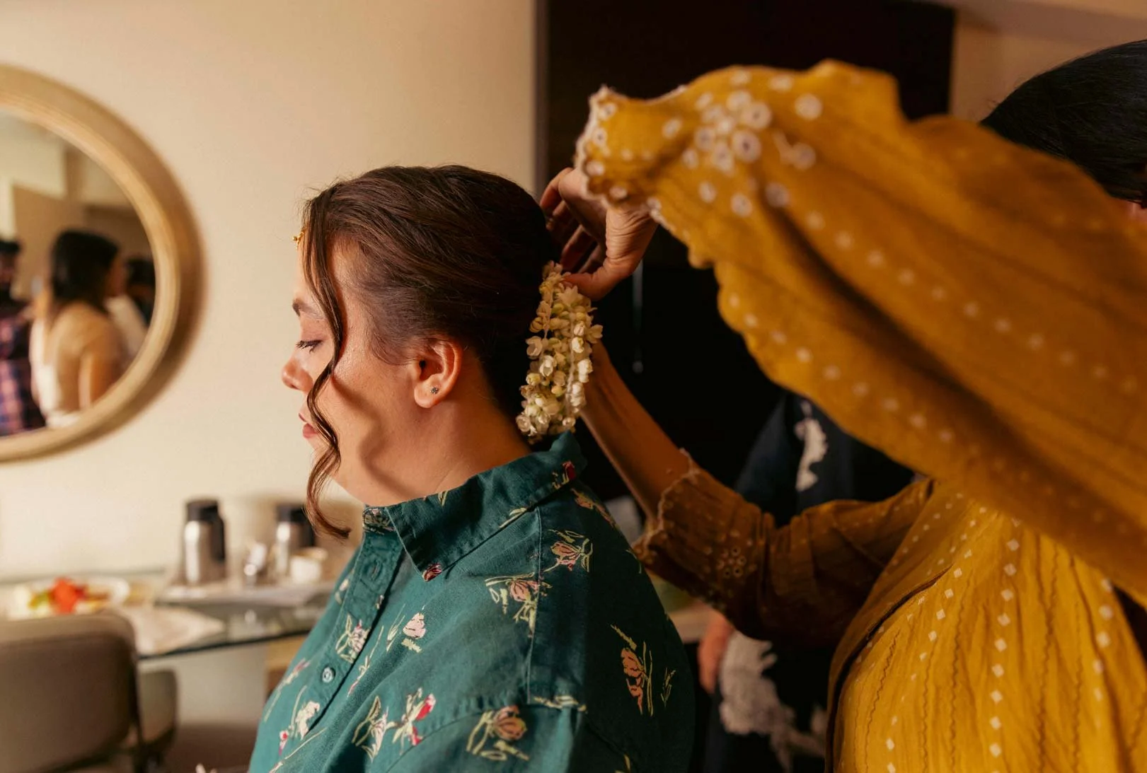 American bride gets ready with jasmine flowers in her hair  for her  traditional South Indian wedding ceremony