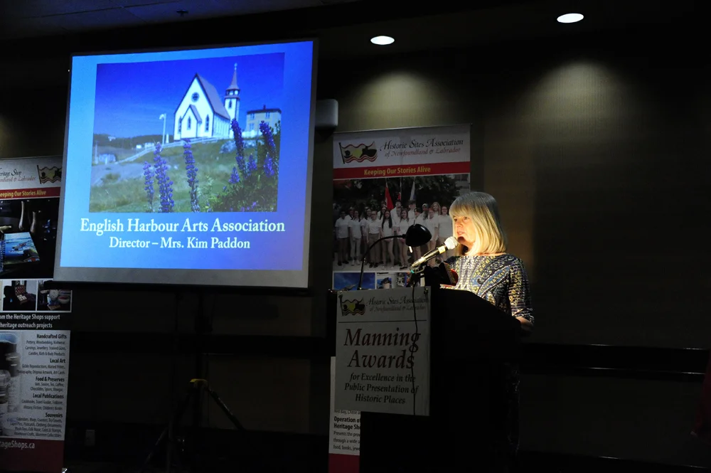 Director Kim Paddon accepting the award on behalf of the English Harbour Arts Association