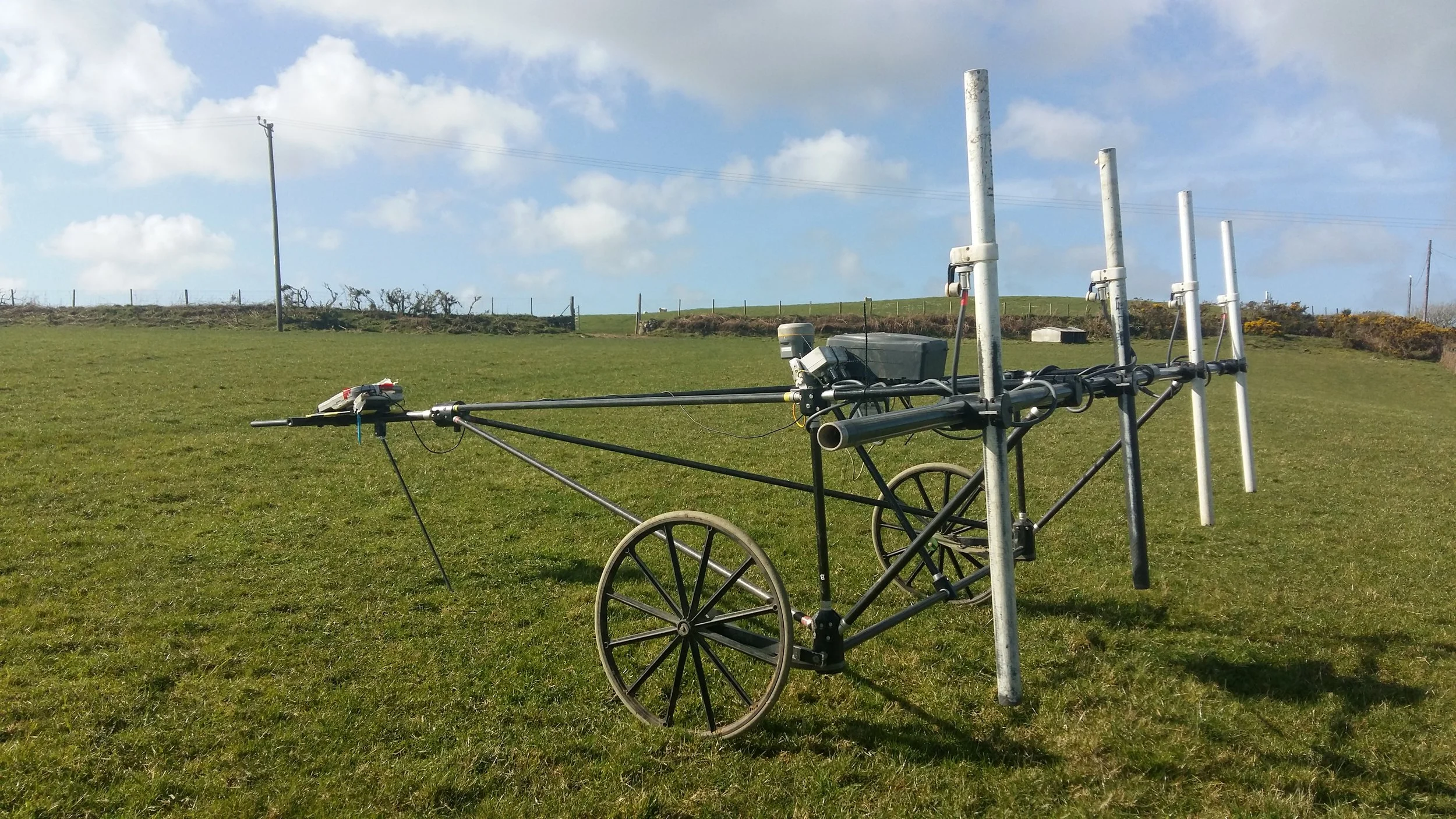 This image shows cart-based magnetometry equipment used for archaeological surveys. The vertical ‘poles’ are sensors which detect small variations in magnetism.