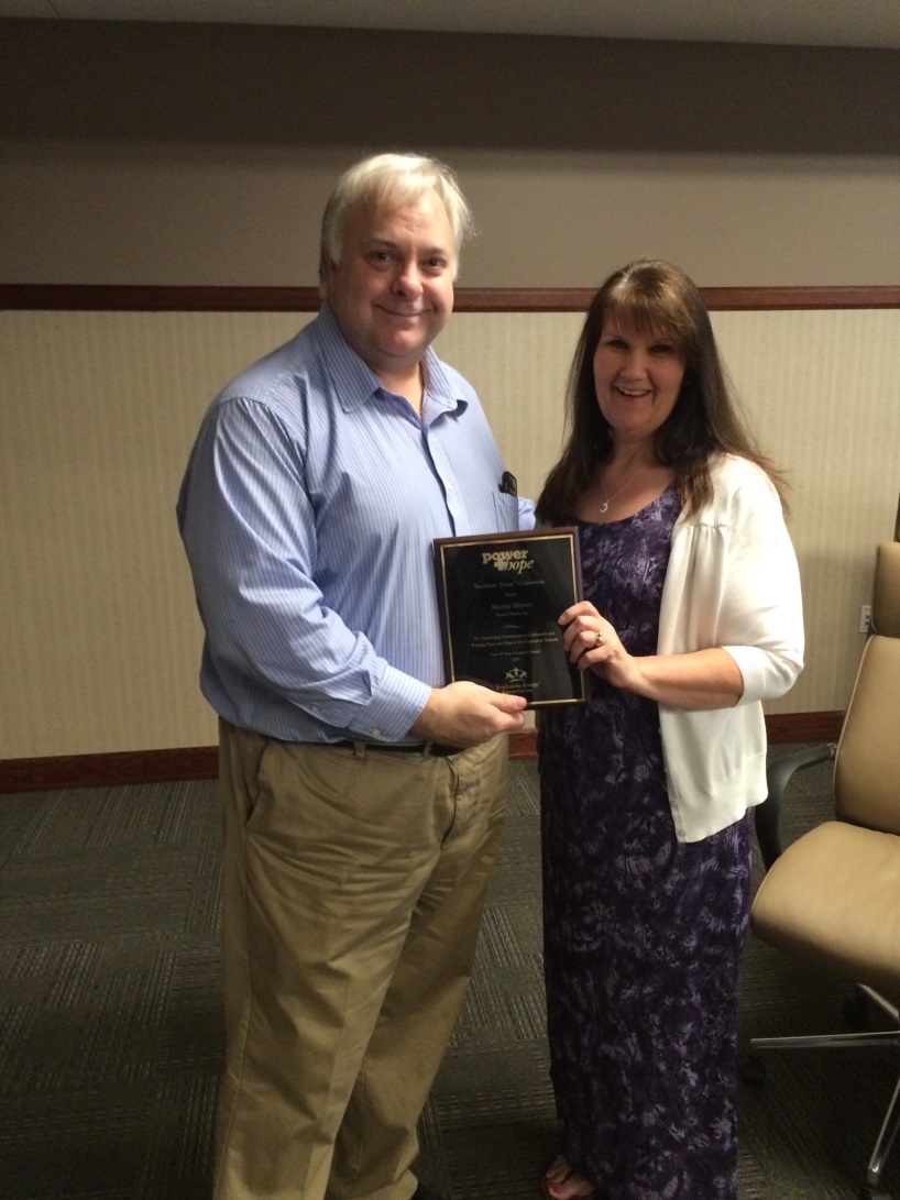 Prairie Power CEO Jay Bartlett presenting the award to Marsha Mayner.