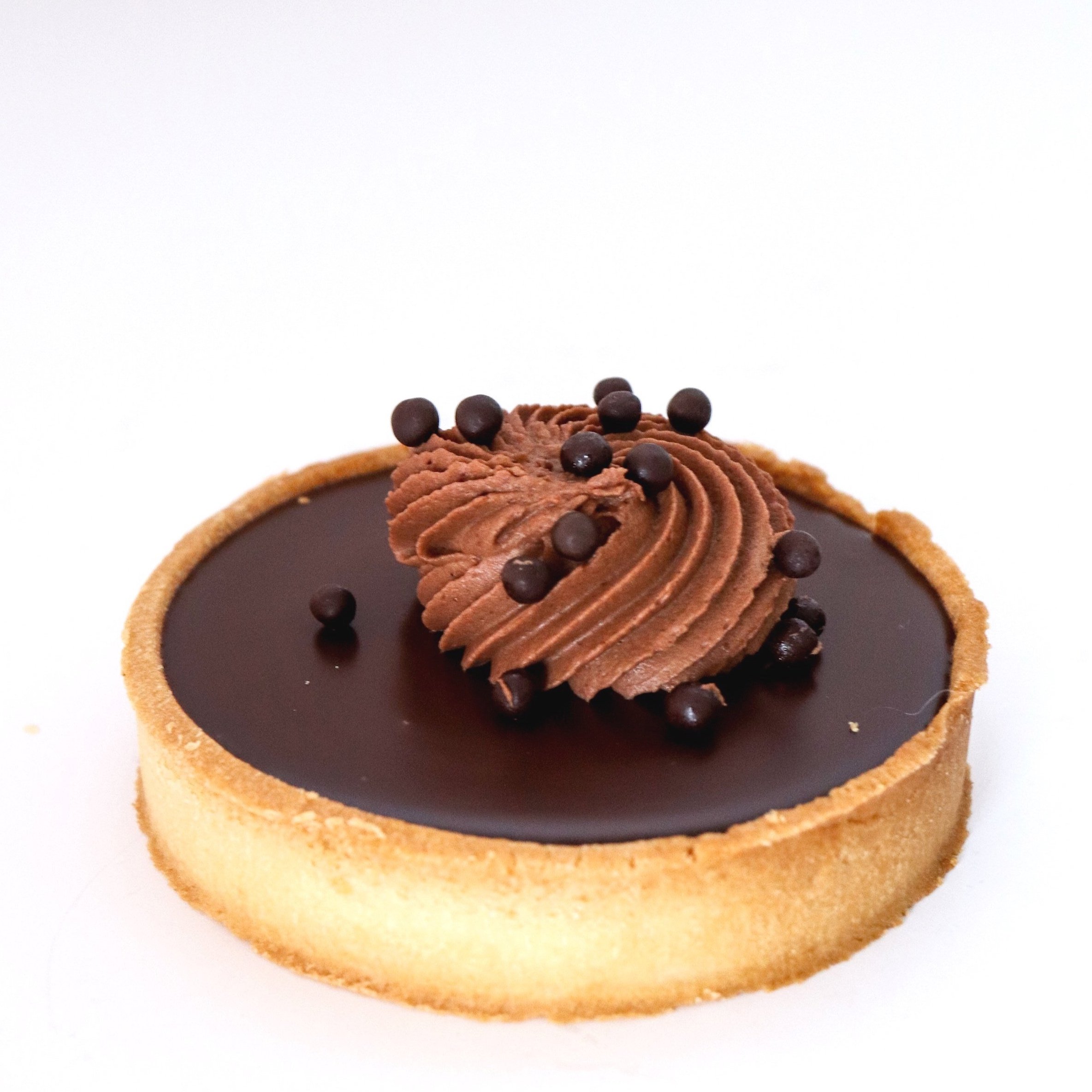 Chocolate tart with a chocolate ganache filling, topped with piped chocolate mousse and small chocolate sprinkles.