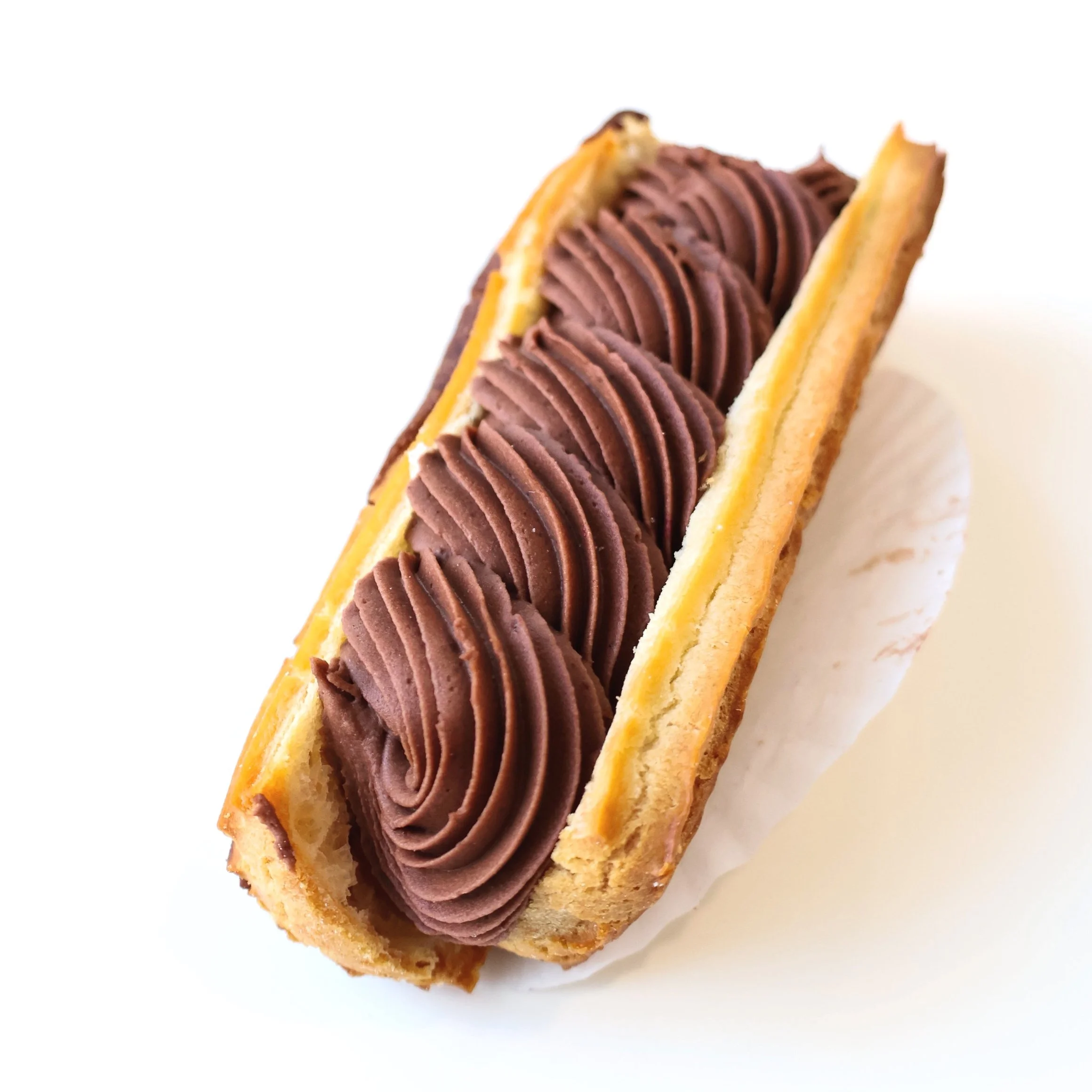 A cream-filled pastry topped with piped chocolate frosting.
