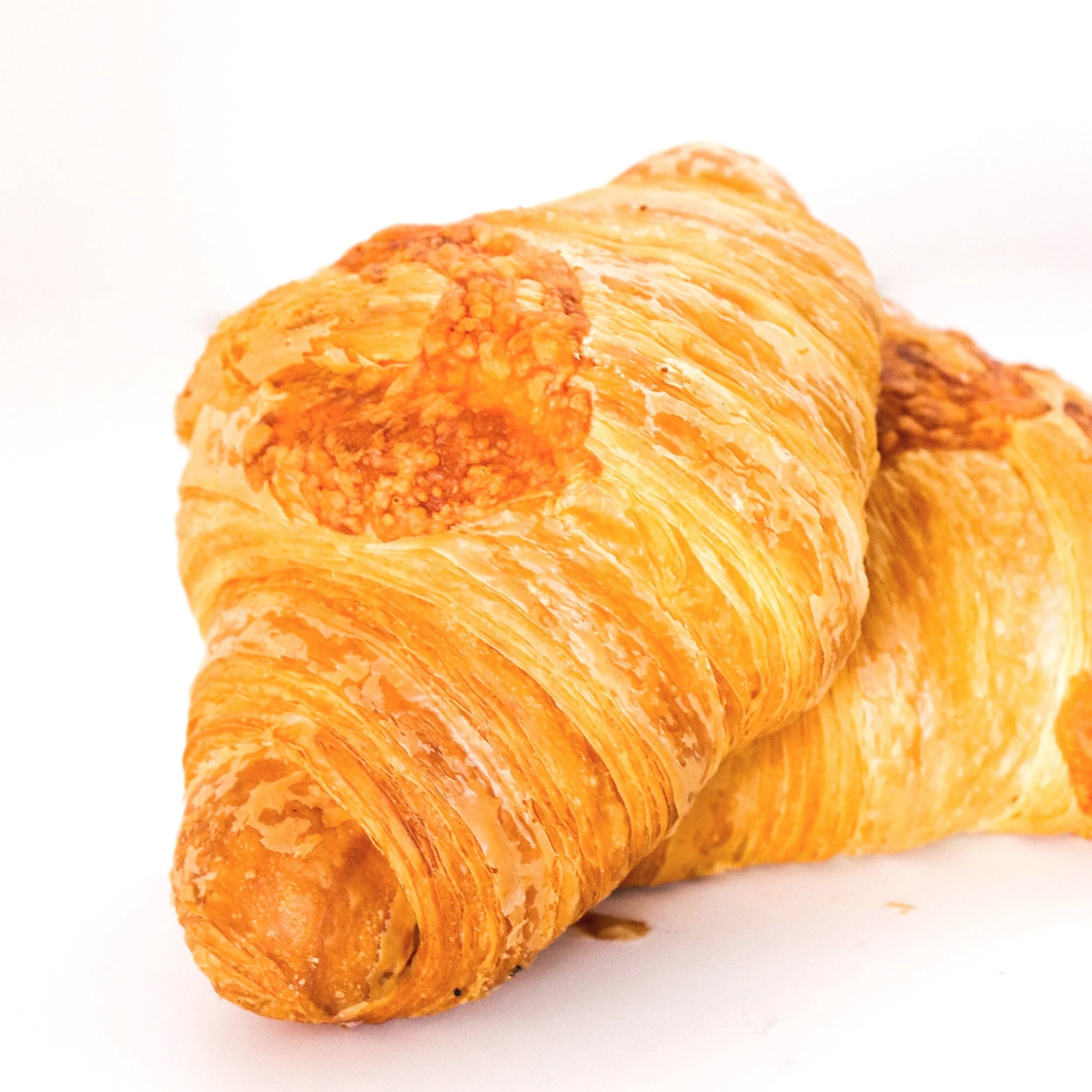 Two golden-brown croissants on a white background.
