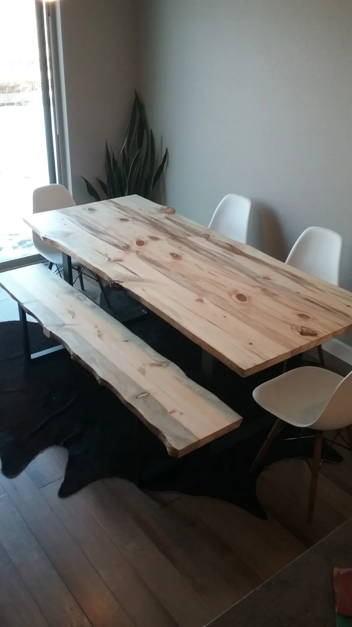 Custom dining table made with three locally harvested beetle slabs. A matching live edge bench, and all resting on a custom fabricated steel frame.