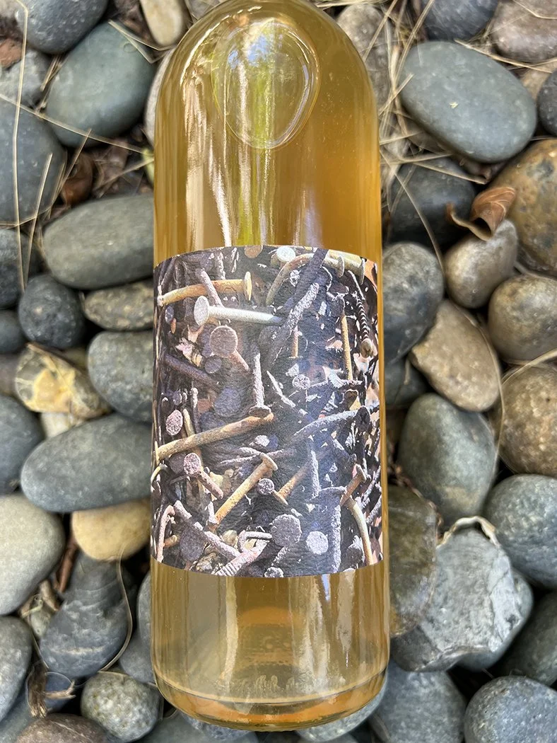 bottle of 2021 j brix island of souls skin-contact white wine blend, beach rocks