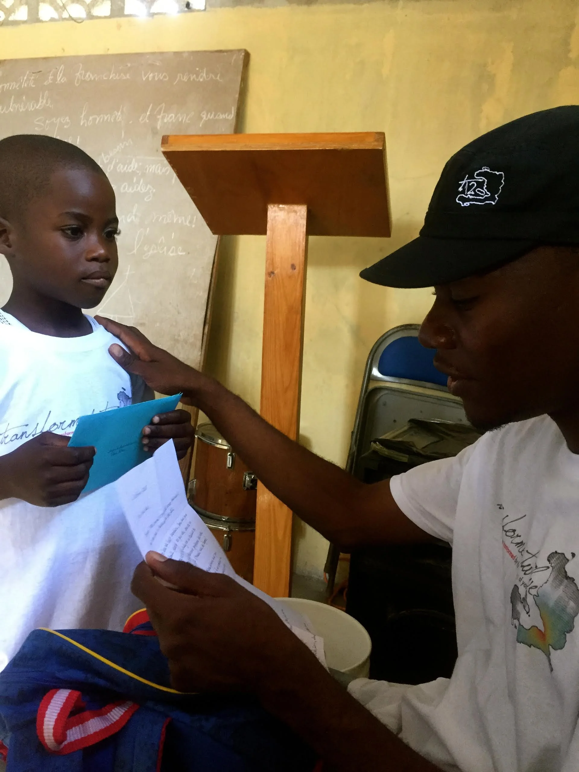 Wadson reading Jean Marc's letter from his sponsor