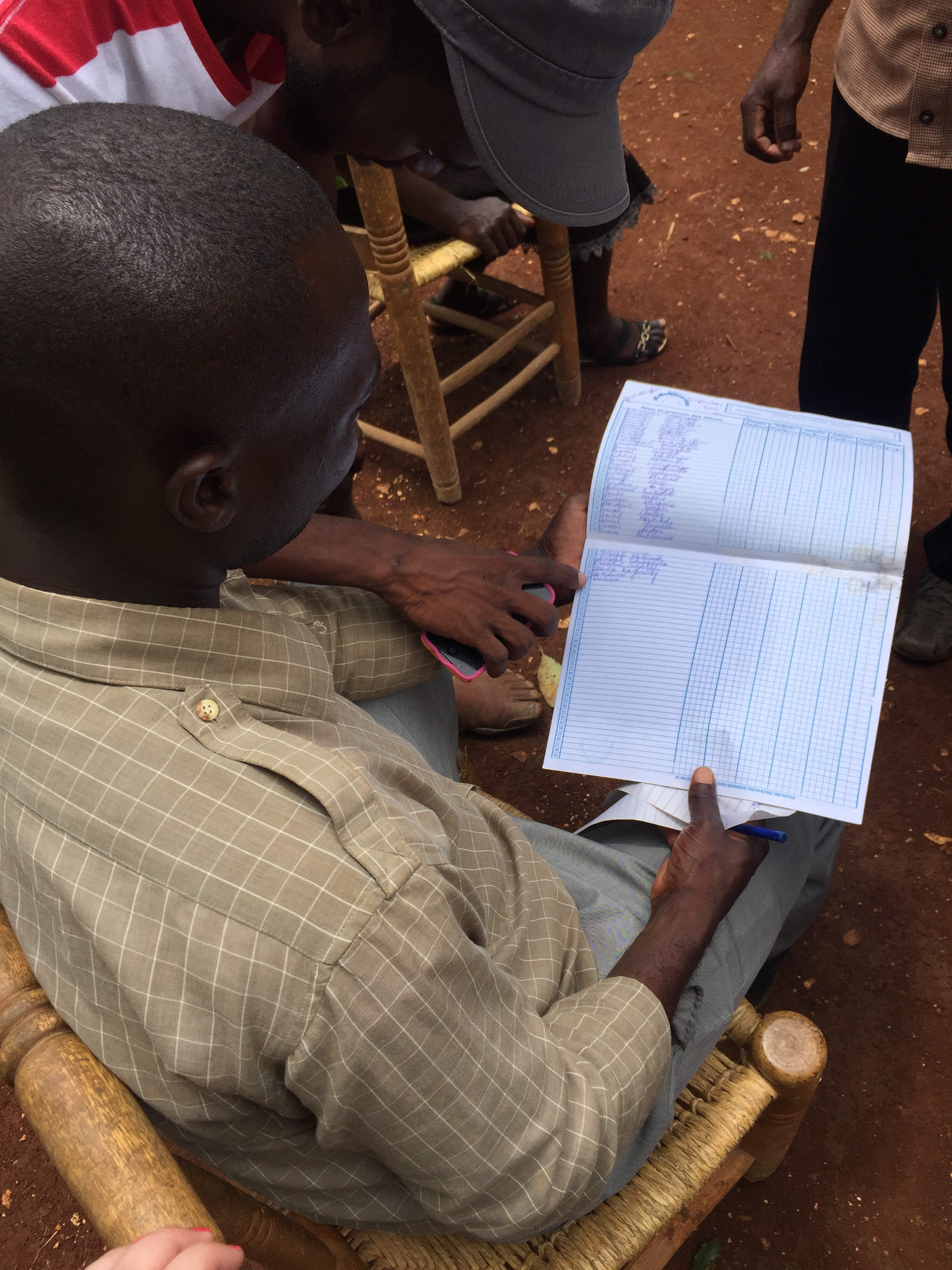 One of the teachers from the school with the list of kids that have shown interest in attending the school again!