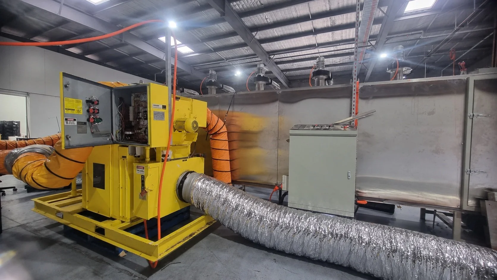 Rental desiccant dehumidifier supplying dry air to Carnivore Pet Kitchen's commercial belt dryer