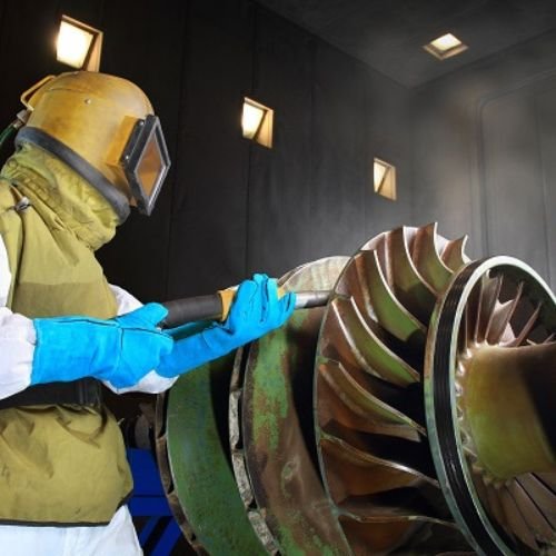 Industrial restoration worker cleaning and preparing turbine equipment