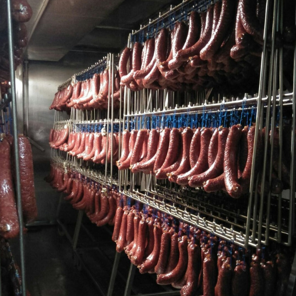 Meat processing facility with hanging product in a humidity and temperature controlled production environment
