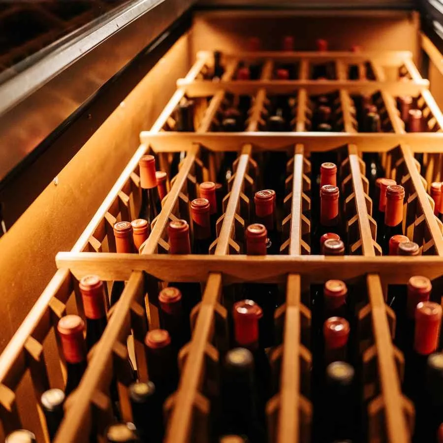Wine bottles stored in a climate-controlled wine cellar using dehumidifier