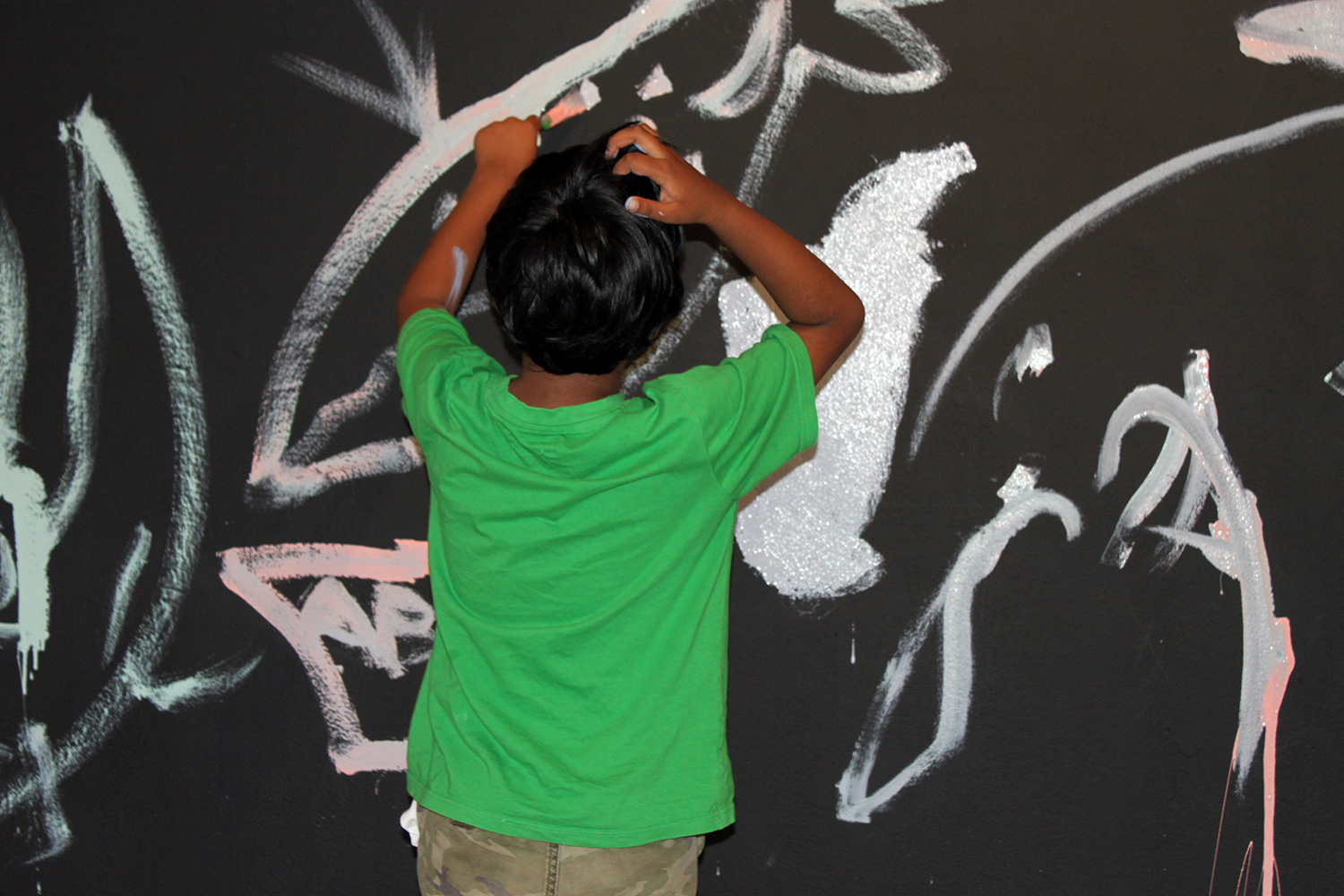 Deshik experimented with paint and brush on the wall. But he scratched his head at how hard it was to control the line.