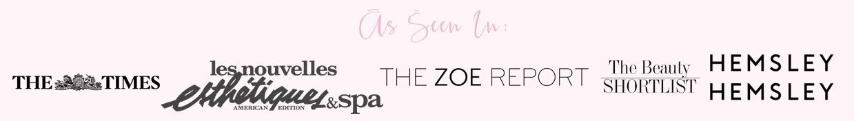 Collection of magazine and newspaper titles and logos including The Times, Les Nouvelles Esthétiques & Spa, The Zoe Report, The Beauty Shortlist, and Hemsley Hemsley, with a pink handwritten phrase "As Seen In" at the top.