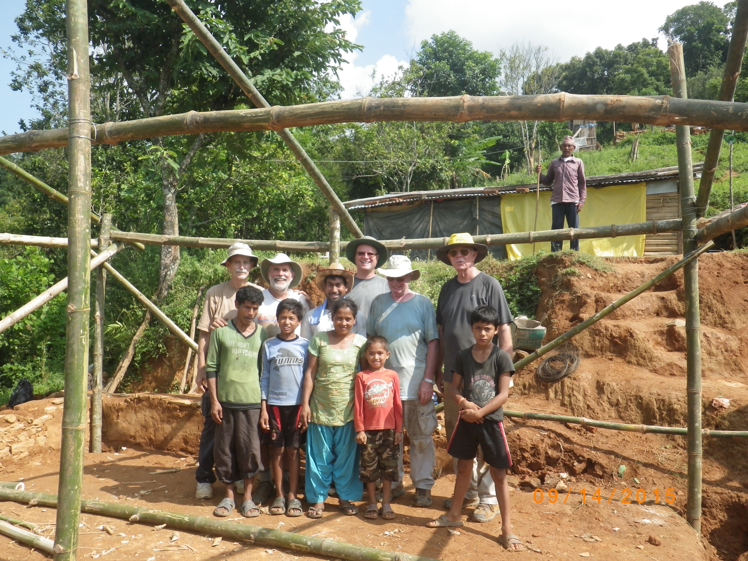 Jerry (right end of the second row) and other volunteers with the family whose house is being rebuilt. 