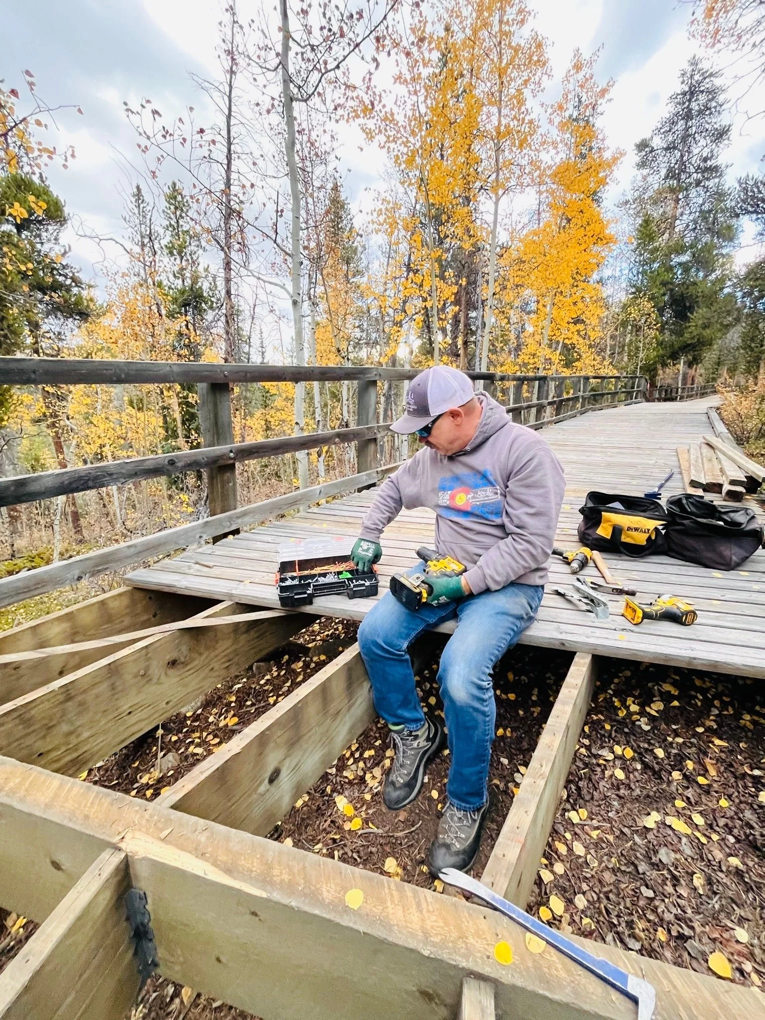 Photo of Justin Bellamy, current Board President, repairing the mountainside boardwalk at Wilderness On Wheels in Grant, Colorado.