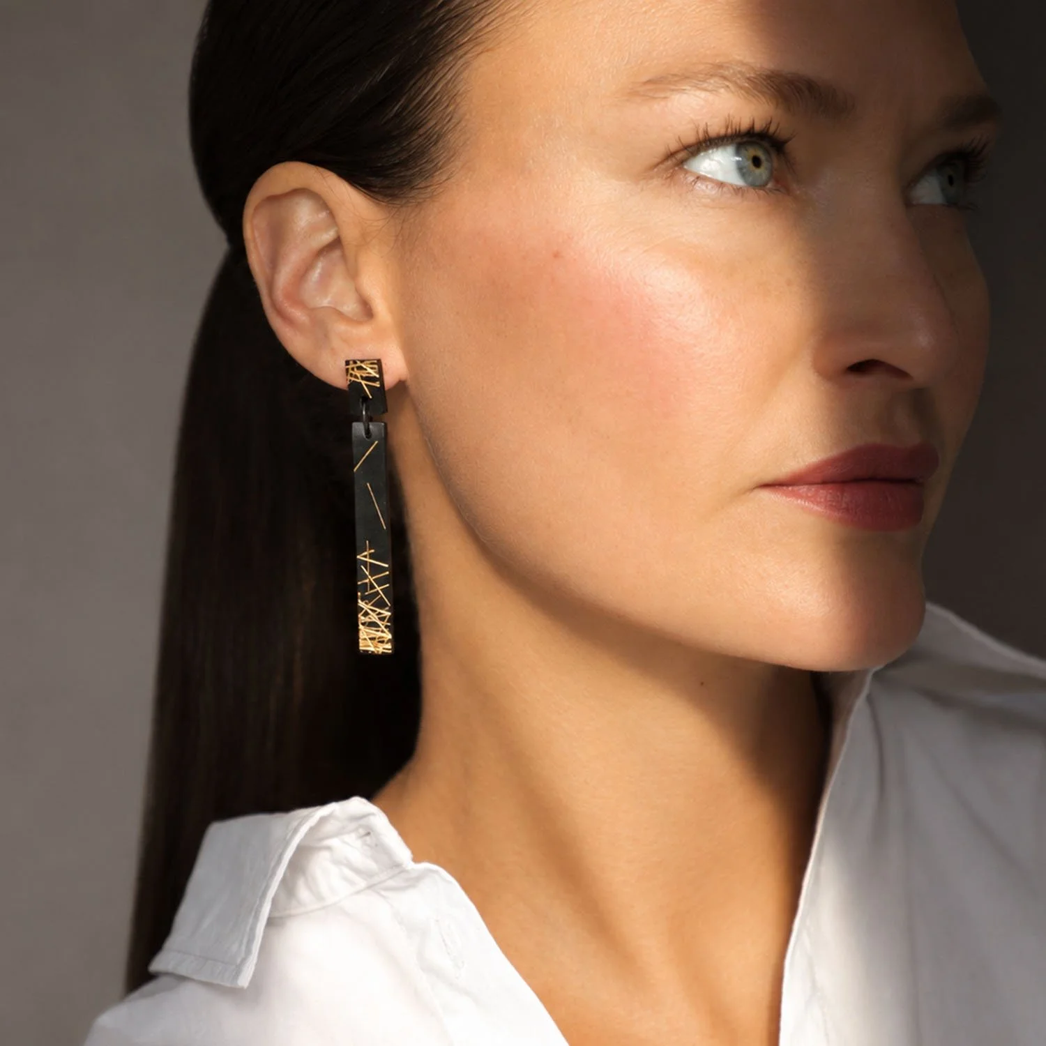 Freehand-lines-leather-drop-earring-black-gold-Tania-Clarke-Hall-modelled.jpg