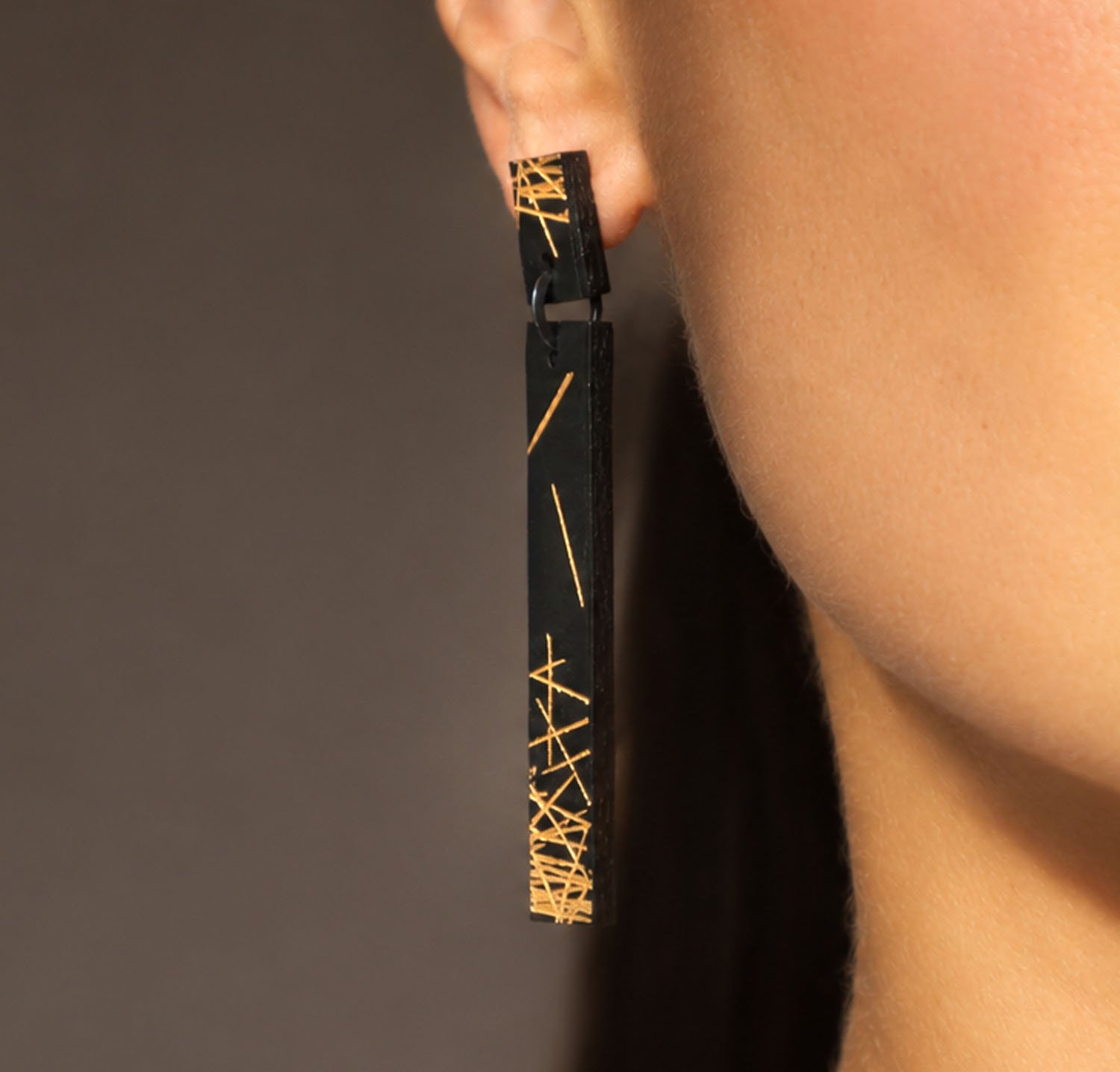 Freehand-lines-leather-drop-earring-black-gold-Tania-Clarke-Hall-modelled-angled-detail.jpg