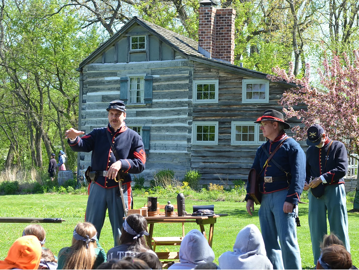 Students listen as a re-enactor discusses battlefield tactics and artillery.