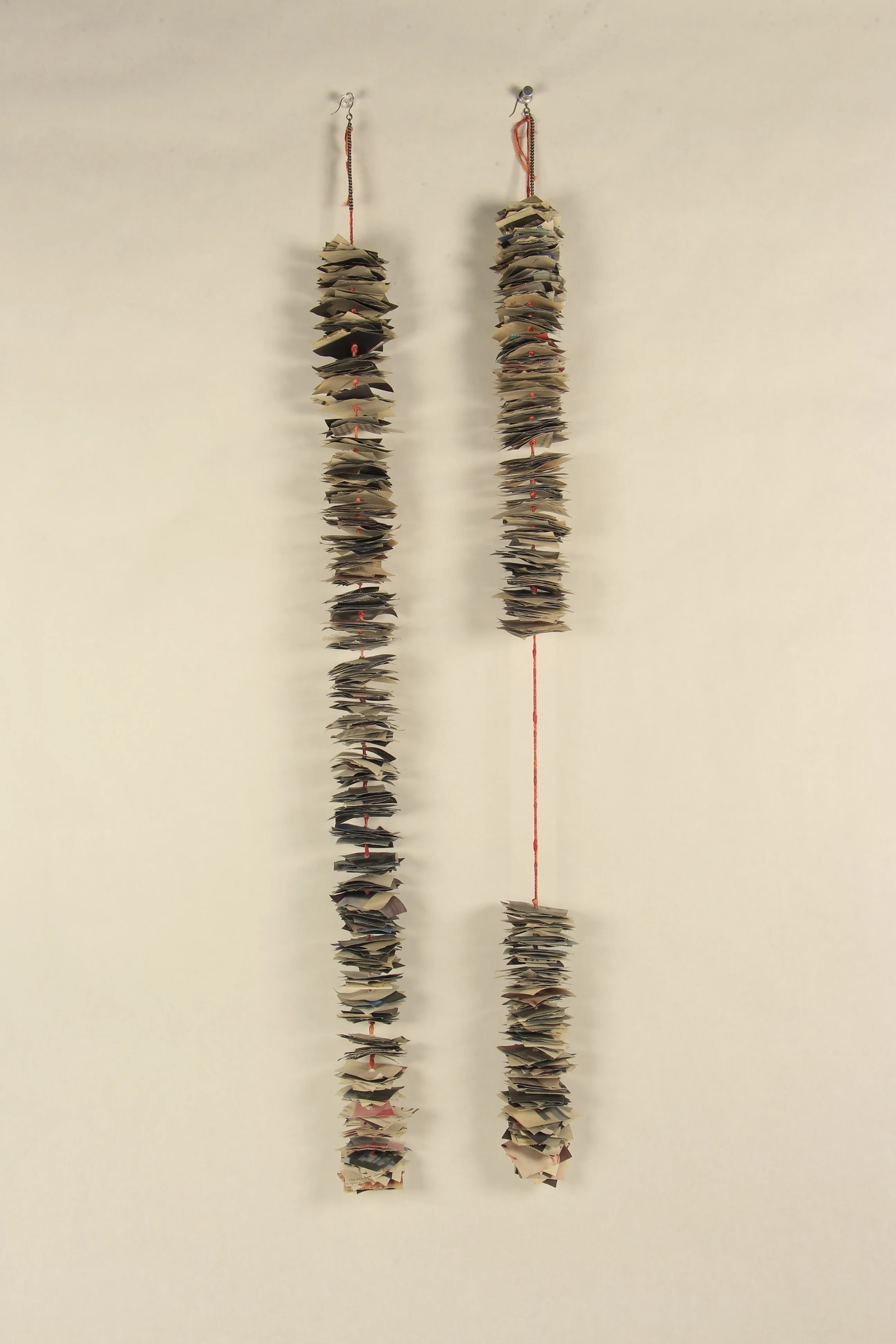  Newspaper Earrings, 2012, newspaper/string/wire, 31”x2” 