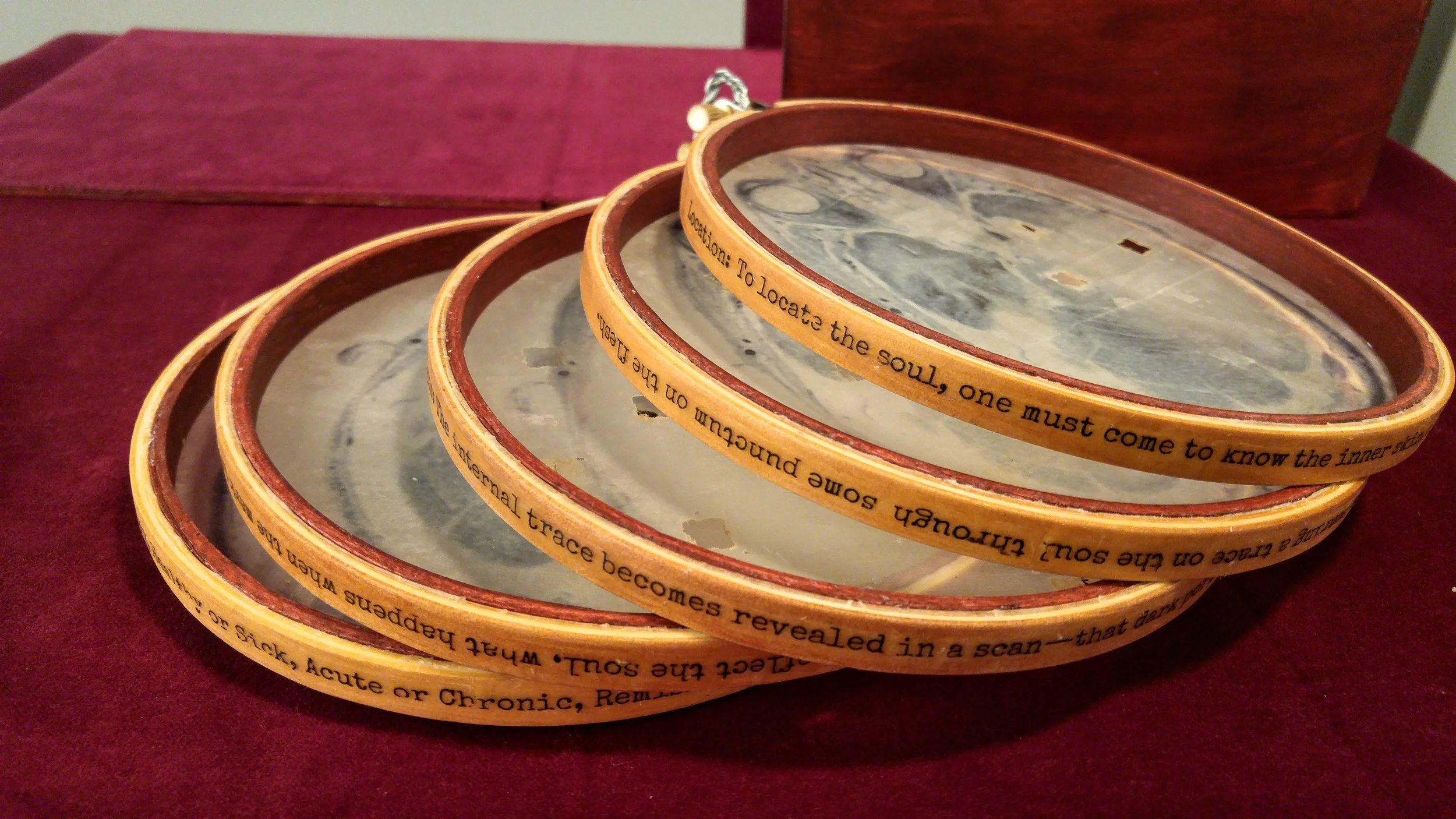 “Underlying Traces,” Encaustic transfer on silk and embroidery hoops, 6” x 6,” 2018.
