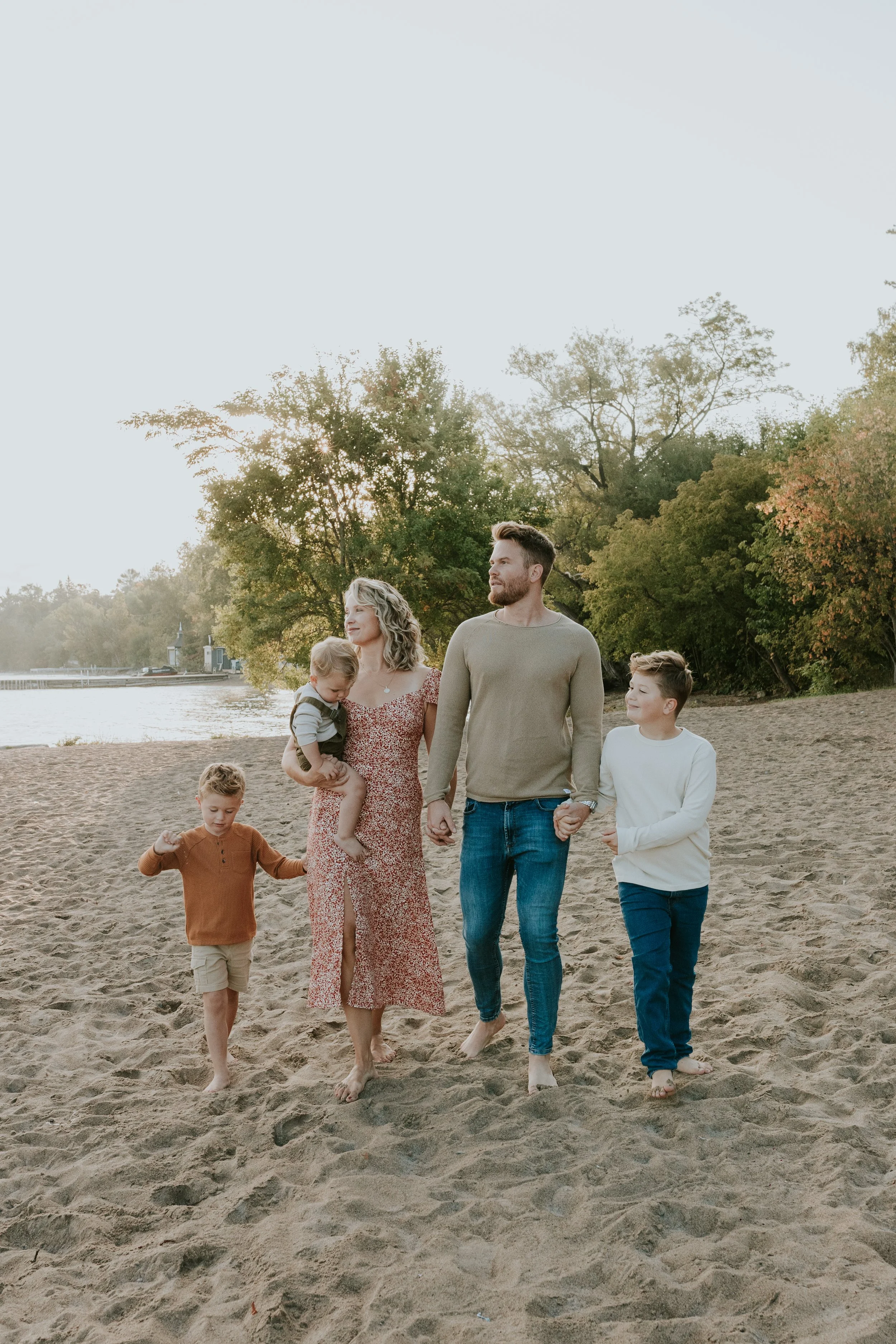 young family walking along de la salle beach in georgina at sunrise for family mini photo shoot