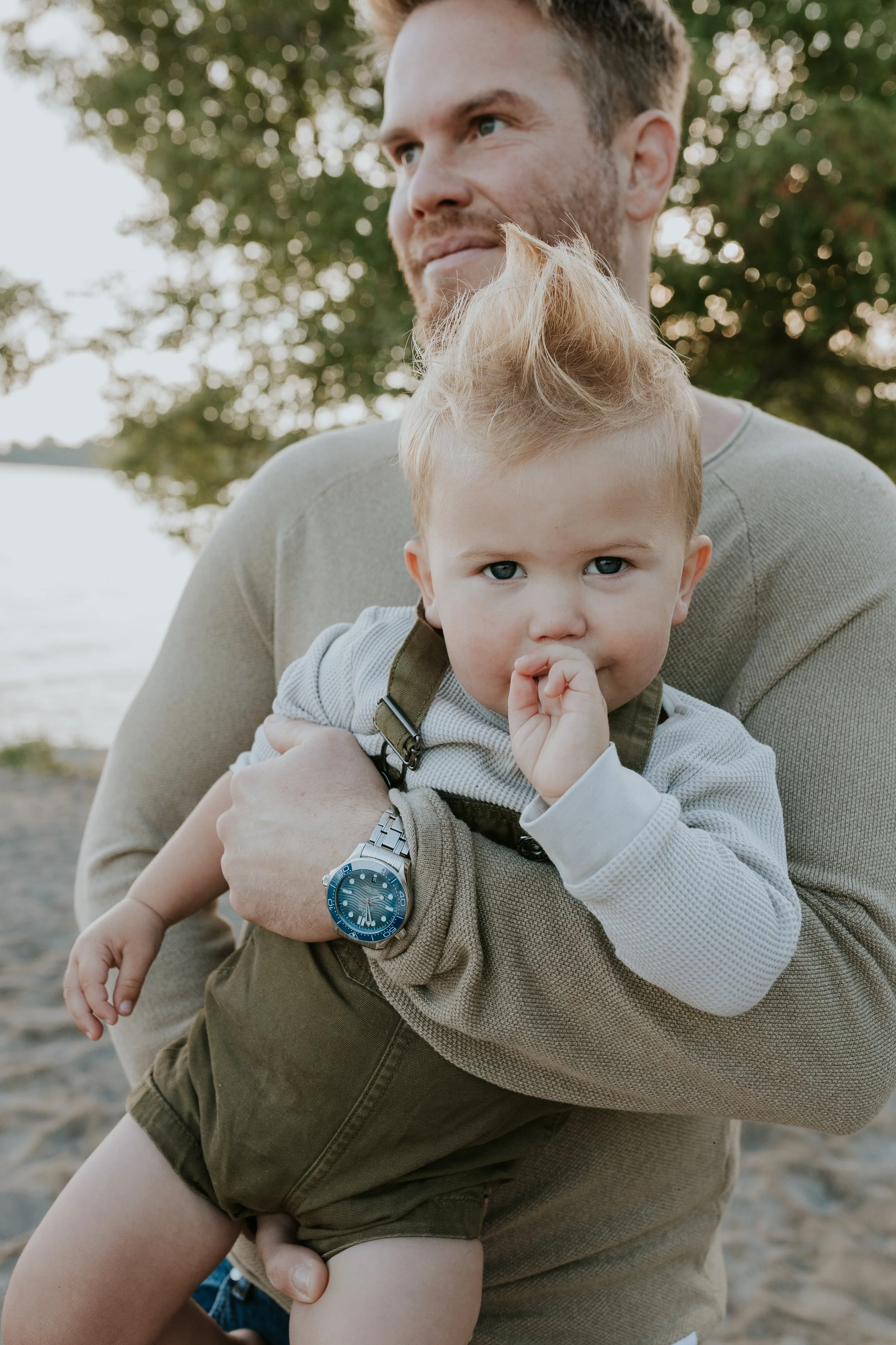 close up of young son in fathers arms during a mini photo shoot at de la salle beach in georgina ontario