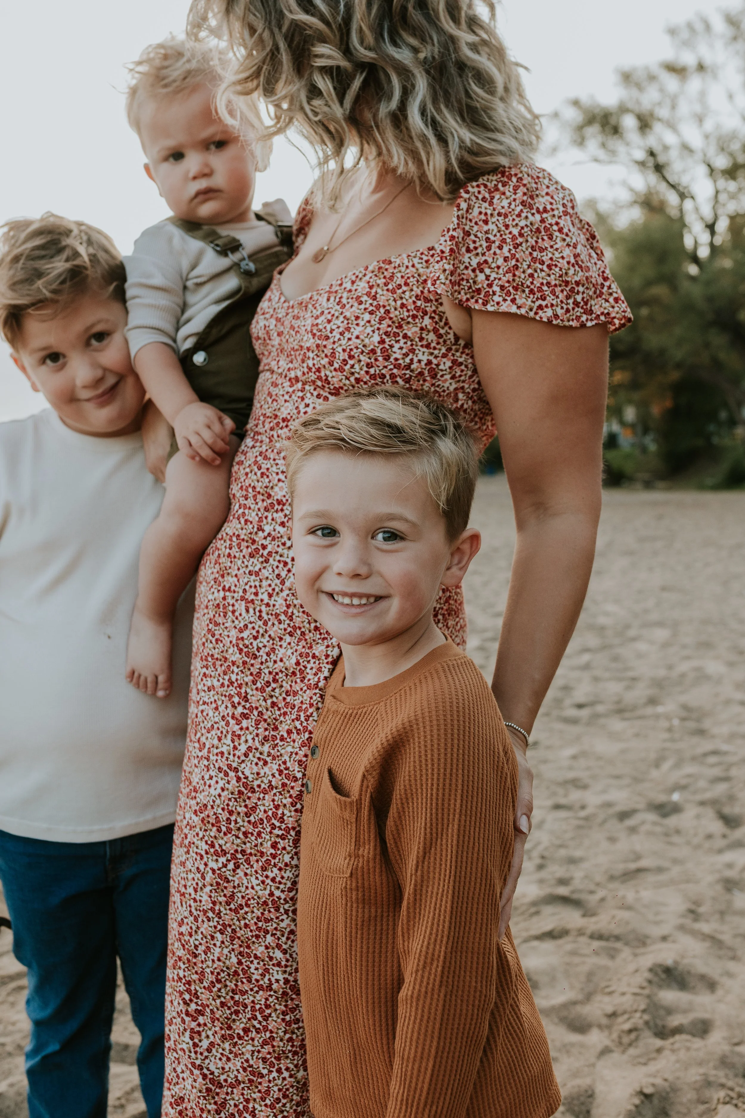 close up of 4 year old son standing next to his mum and brothers on the beach at de la salle in georgina ontario