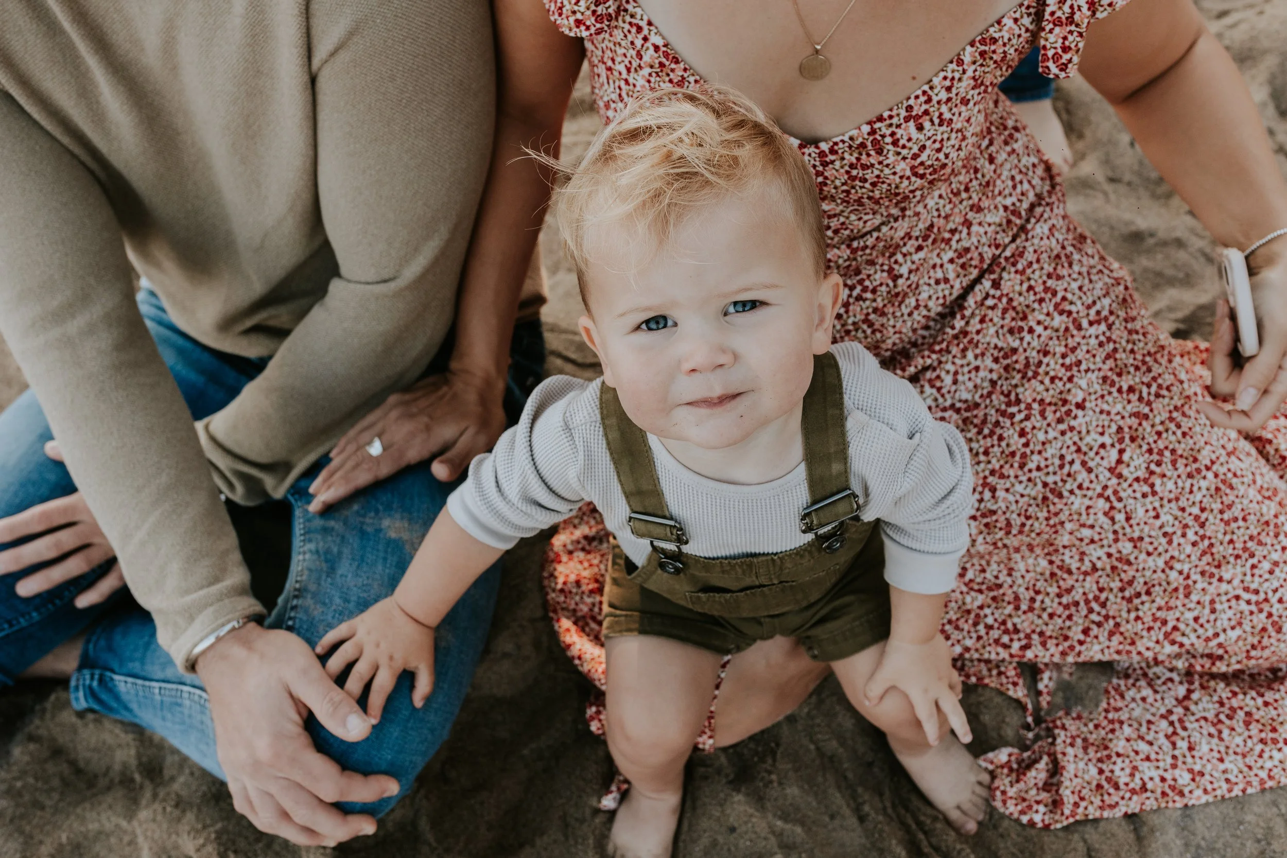 close up of young boy sat on his mums lap during family photos at de la salle beach in georgina ontario
