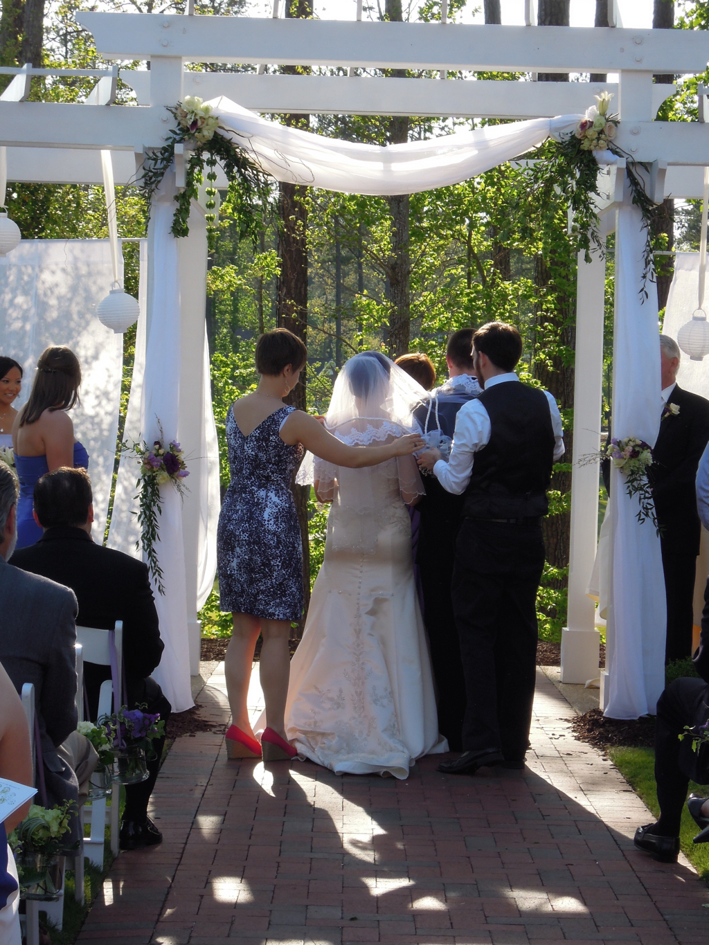  The parents of the bride drape the veil over her head and around the groom's shoulder.&nbsp; 