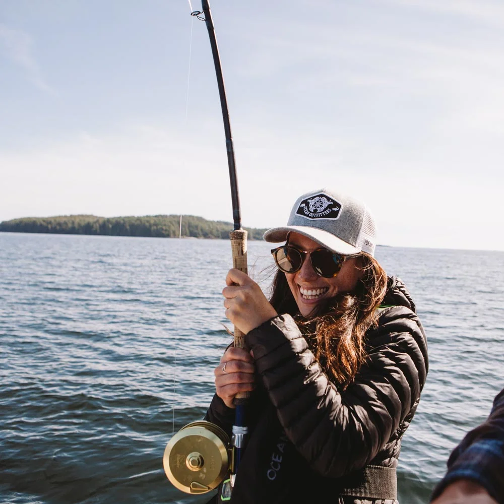 A lady with a Salmon on the line on our offshore fishing trips.