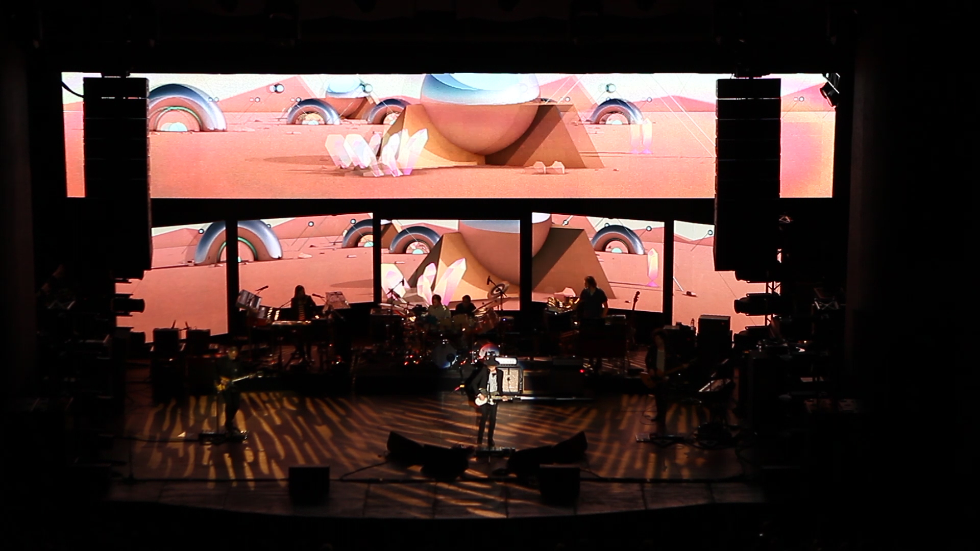 Stills from Beck's concert with visuals displayed behind the band.