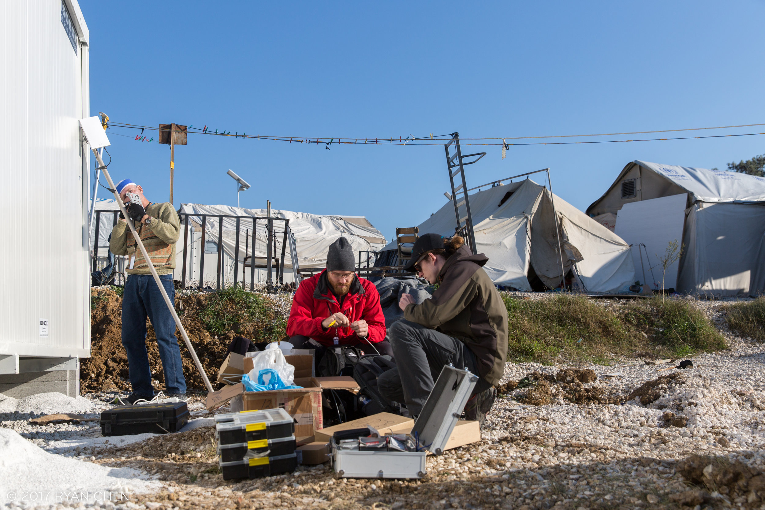 NetHope volunteers David Cryer, Mike Papadodimas (Cisco) and Charles Hall (Google) preparing to install an access point, Diavati Camp, Thessaloniki.