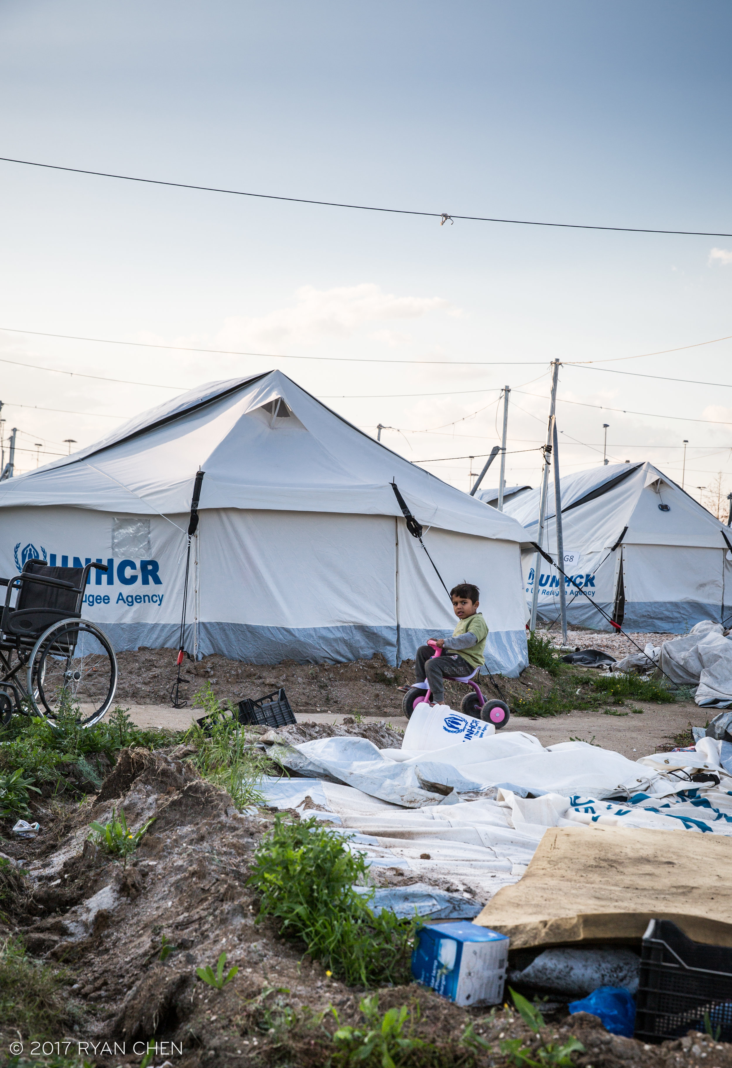 A child riding his tricycle in Ellinko camp which is situated in the former olympic baseball stadium in Athens.