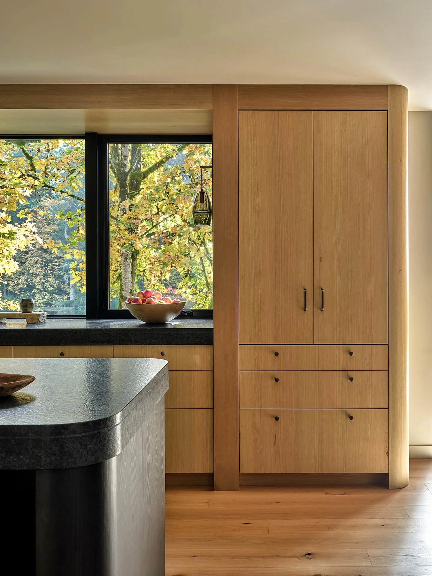 Cabinetry serves not only as practical storage but also as a space-defining tool. We softened the edges, topped them with beautiful textured granite, and created high and low contrast through varied stain formulas. 

Architecture and Interior Design 