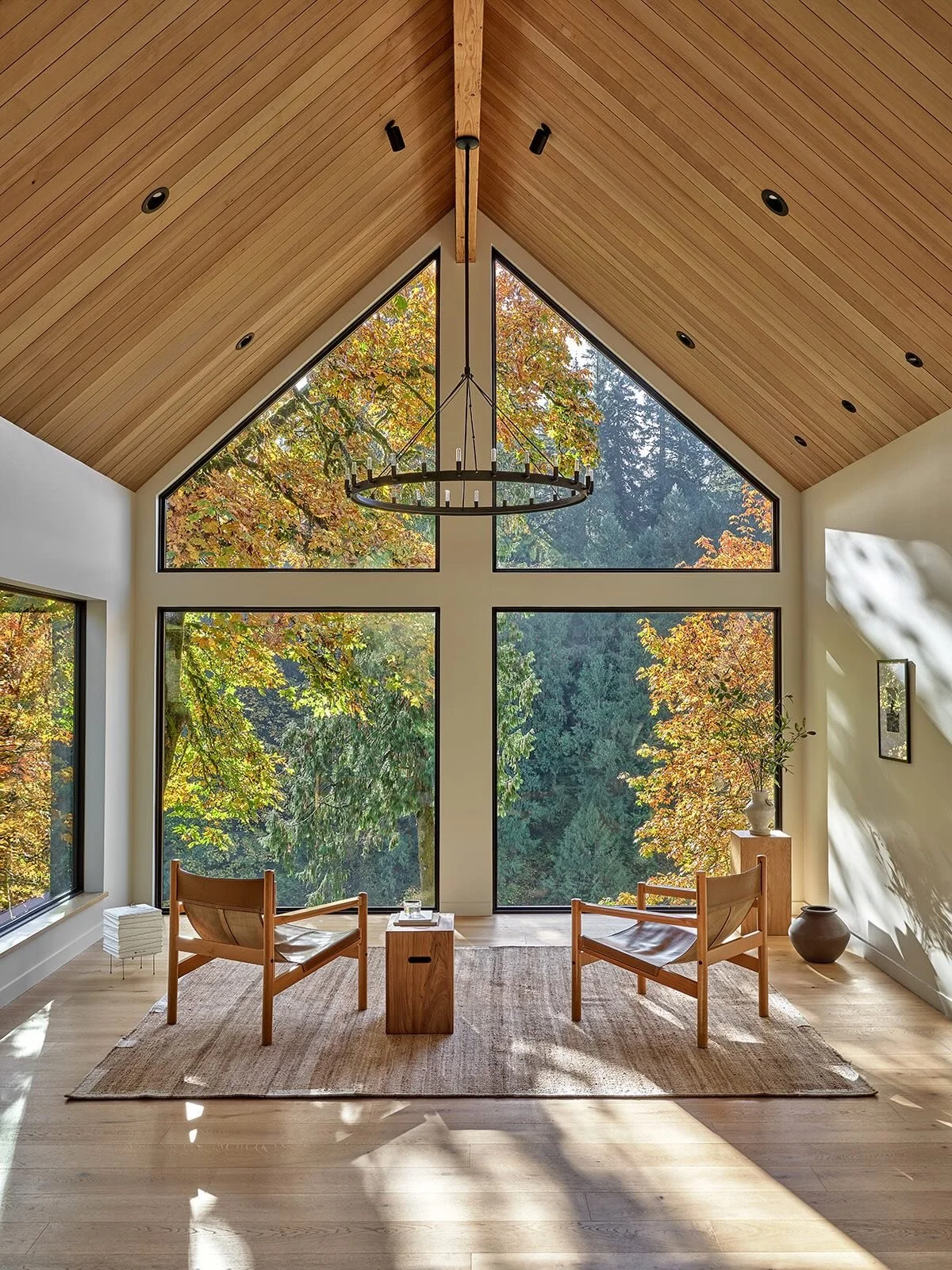 A treetop living room at Sockeye -> swipe to see the before.  The bulky central stair, which led to a very secondary room, moved to a more discrete location, making way for a new fireplace location that could be celebrated and used often.  The det
