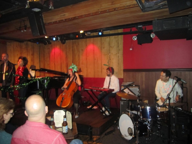 L to R: Adam Enright & Madison McFerrin, backup vocals, Aya Kato as RASTA SANTA, Erin Hall w/Holiday Hat by BRIJ DESIGN, Gabe Shuford on Keys, John Bollinger on drums (NOT PICTURED-- Lars Jacobsen on Tenor Saxophone. Special Thanks to Will running sound! ! ! #RockwoodMusicHall #cello #comedy #holiday