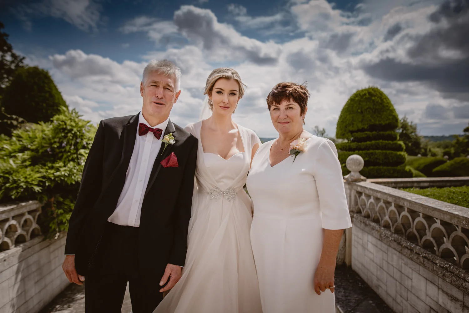 Group photo of the bride, her father and her mother during the wedding day at Danesfield Hotel Wedding Venue in Marlow-On-Thames, Buckinghamshire