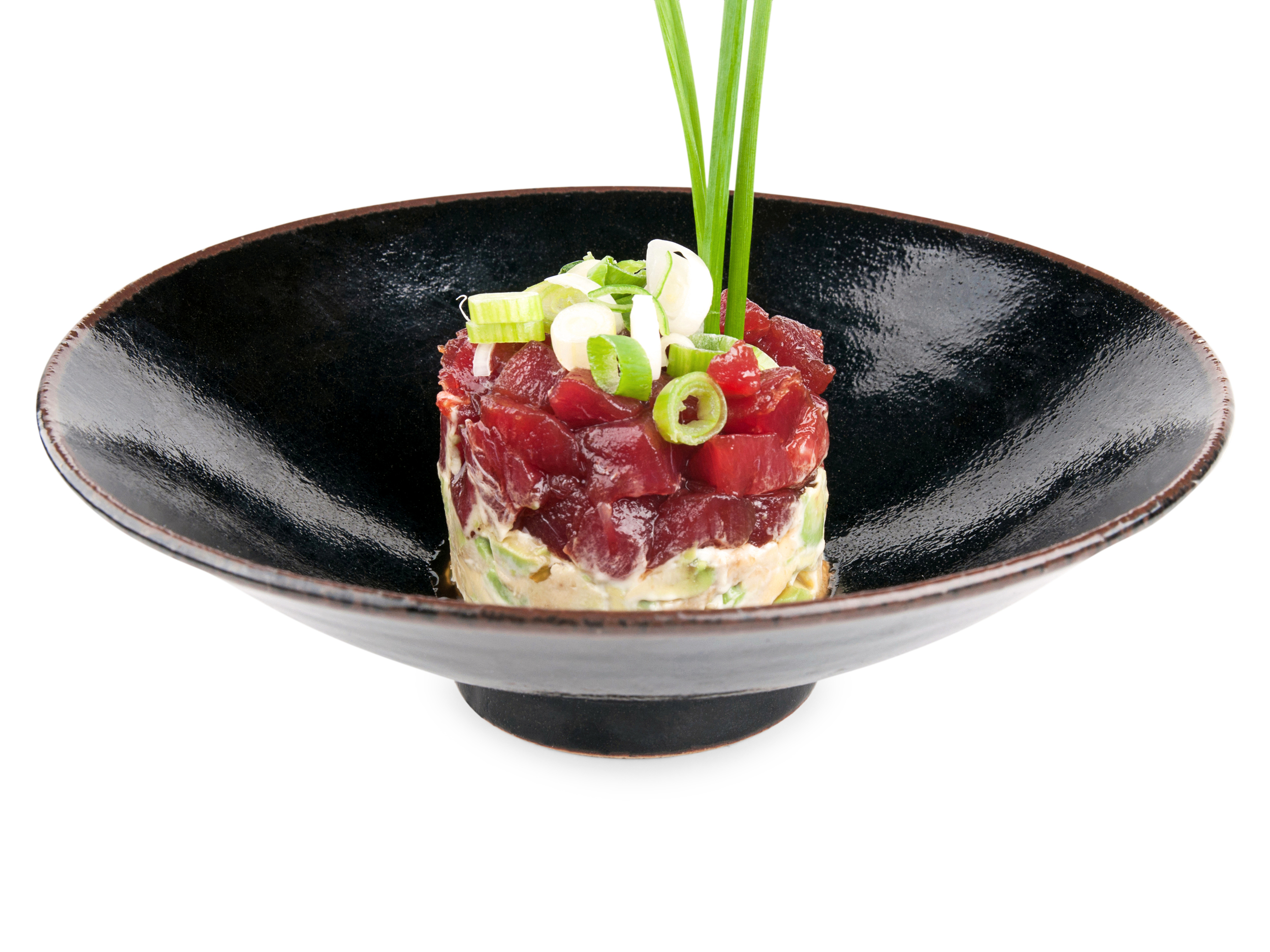 Tartar de atún blue fin marinado. Cortado a cuchillo con un ligero tostado sobre una base de aguacate.
