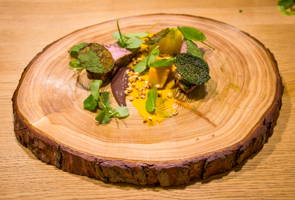  Roast lamb, pumpkin, peat, sloes and wild herbs on a homemade pine plate 