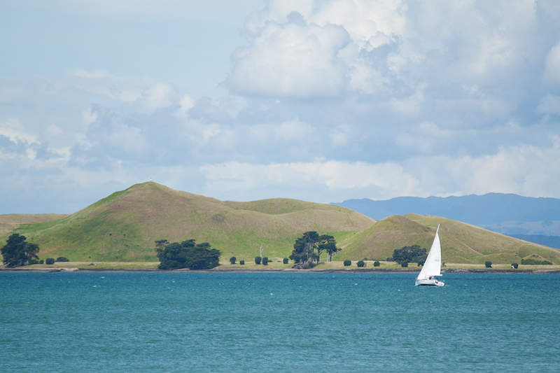 The sailboat in the foreground adds a contrast to the background, and therefore a sense of depth to the scene