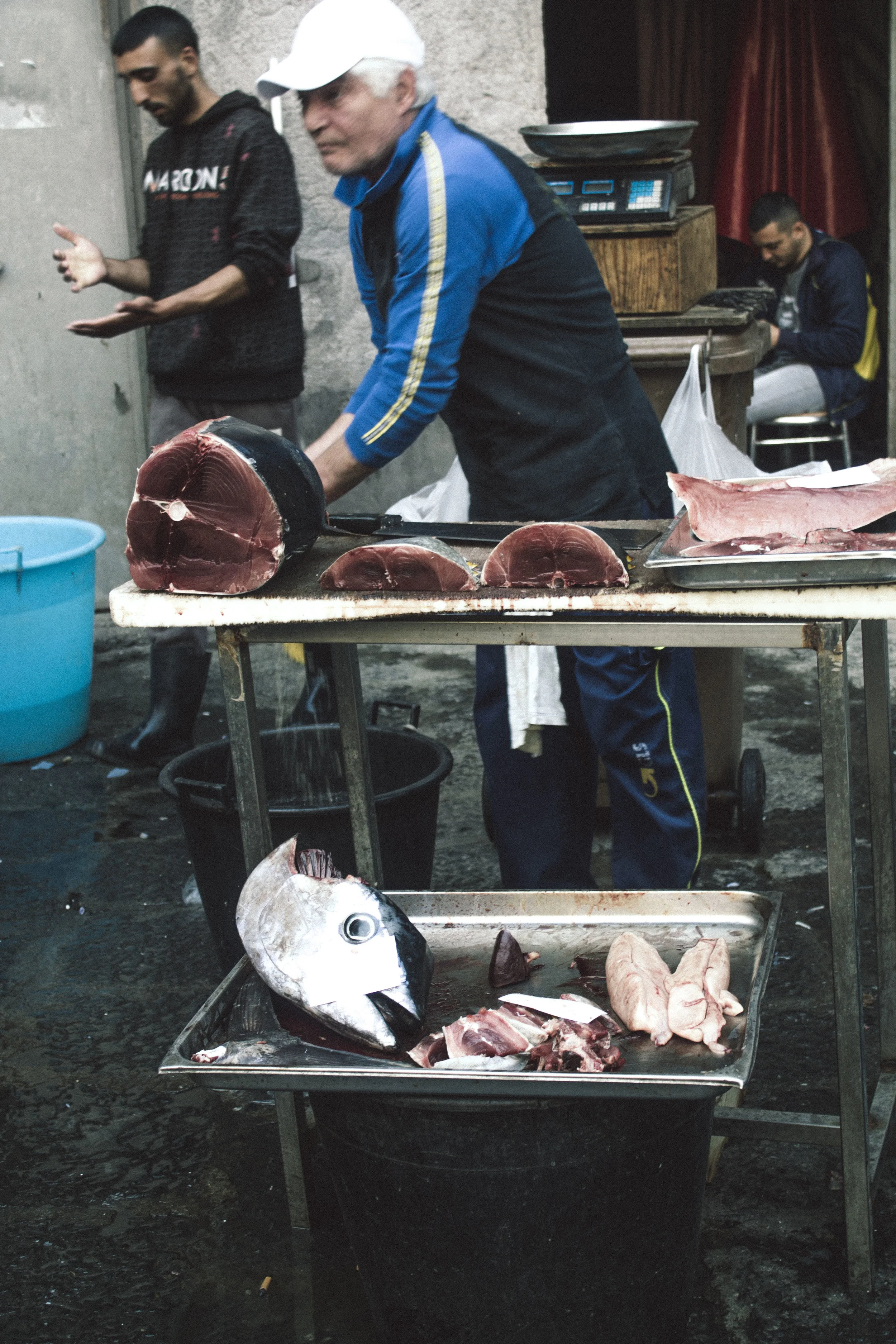 Vendors preparing their fish at La Pescheria, Catania, Sicily