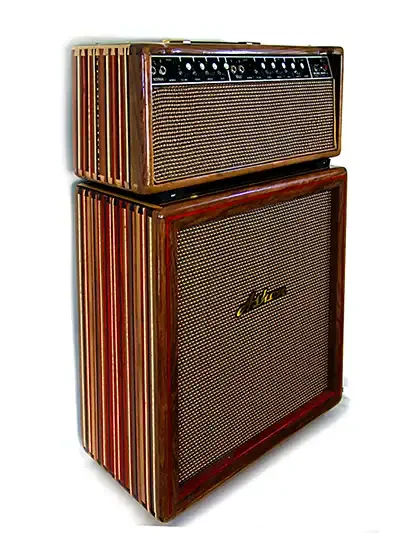 Custom made boutique guitar amplifier on top of matching speaker cabinet built of different kinds of exotic wood